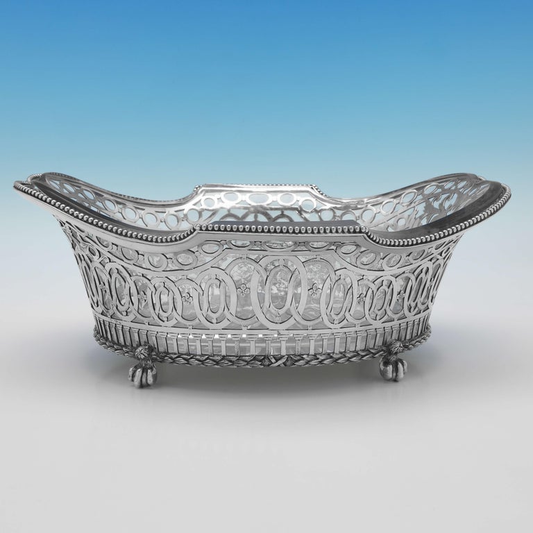 Hallmarked in London in 1890 by Dobson & Sons, this attractive, Victorian, antique sterling silver dish, stands on 4 ball and claw feet, and features bead detailing, pierced and engraved decoration and a glass liner. 

The dish measures 4.5