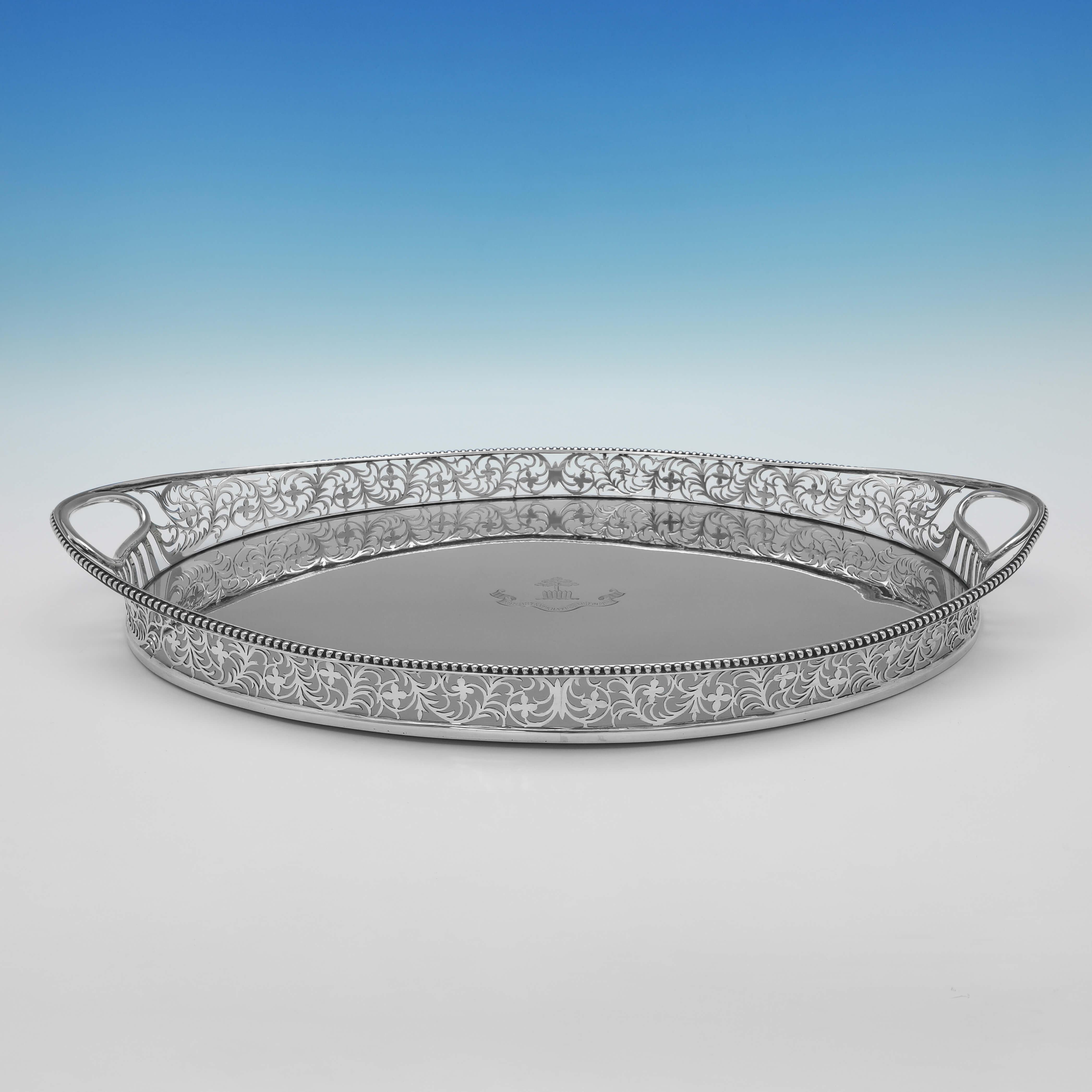 Hallmarked in London in 1900 by Charles Stuart Harris, this attractive, Antique Sterling Silver Gallery Tray, features a pierced and decorative gallery border, and an engraved crest and motto to the centre. 

The tray measures 2.5