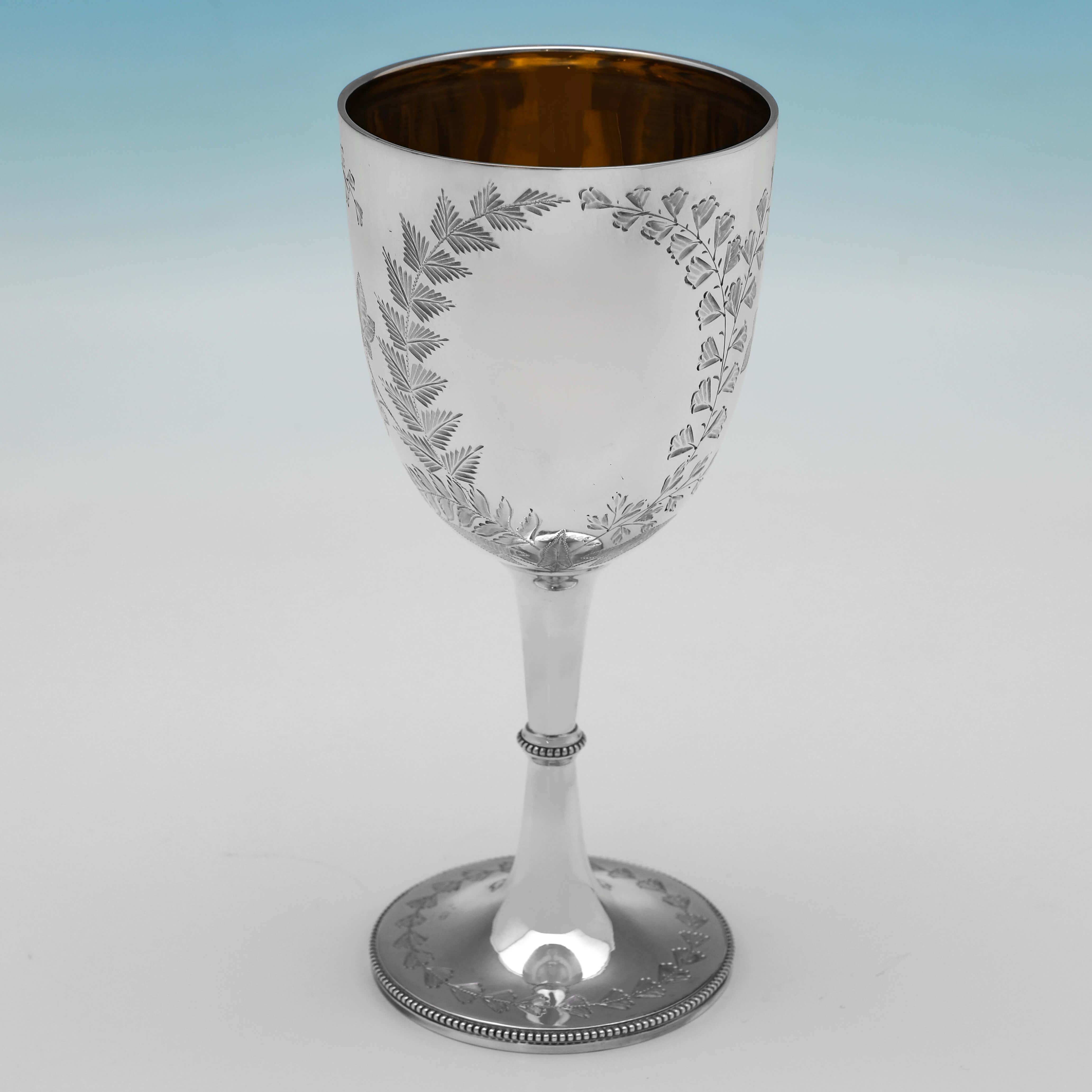 Hallmarked in Sheffield in 1883 and 1884 by Henry Atkin, this attractive pair of Victotian, Antique Sterling Silver Goblets, feature fern engraved decoration, bead borders, and gilt interiors. 

Each goblet measures 7