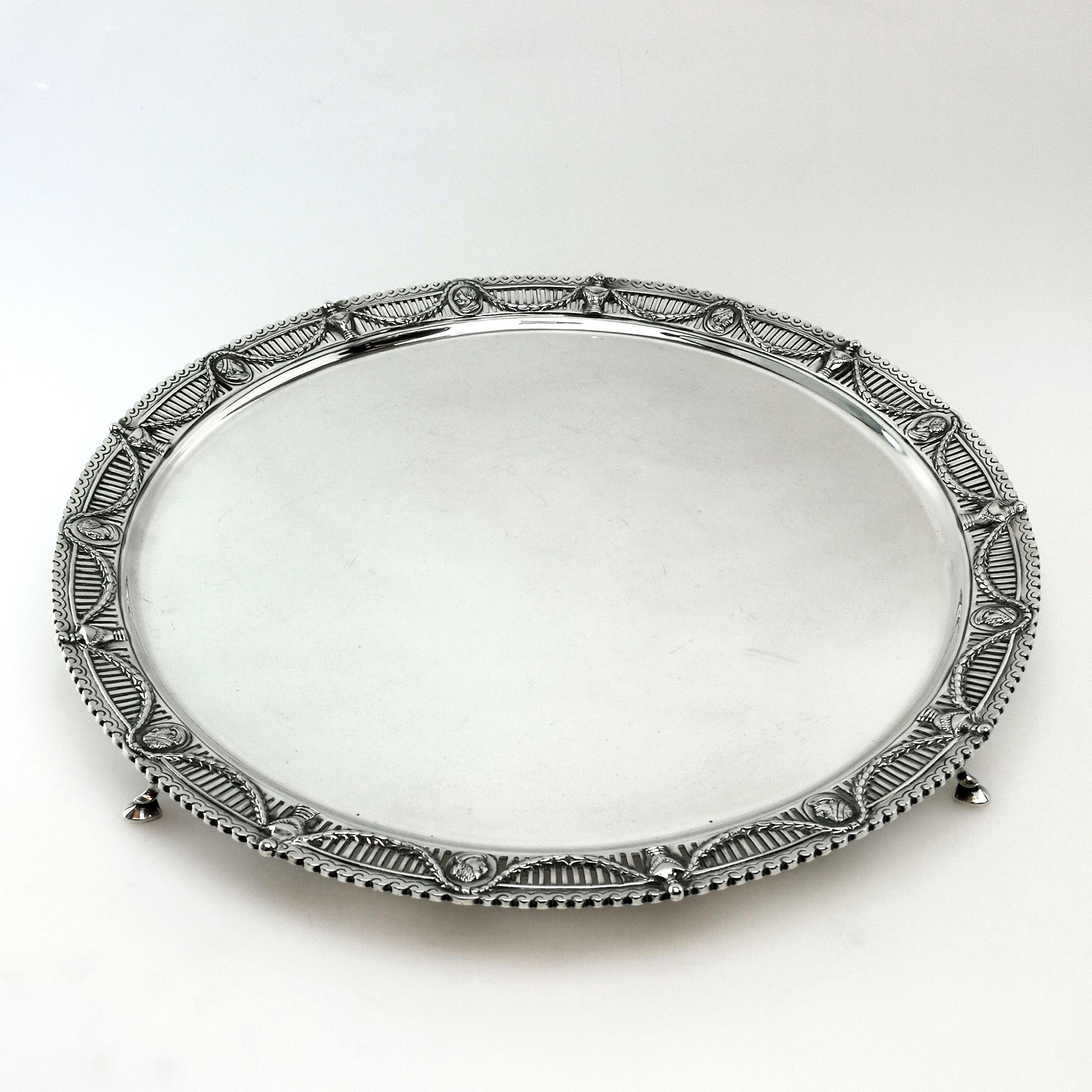 A magnificent Antique Victorian solid Silver Salver. This round Silver Tray stands on four hoof feet and has an impressive rim featuring a pierced pattern embellished with a swag design and interspersed with oval cartouches filled with classical