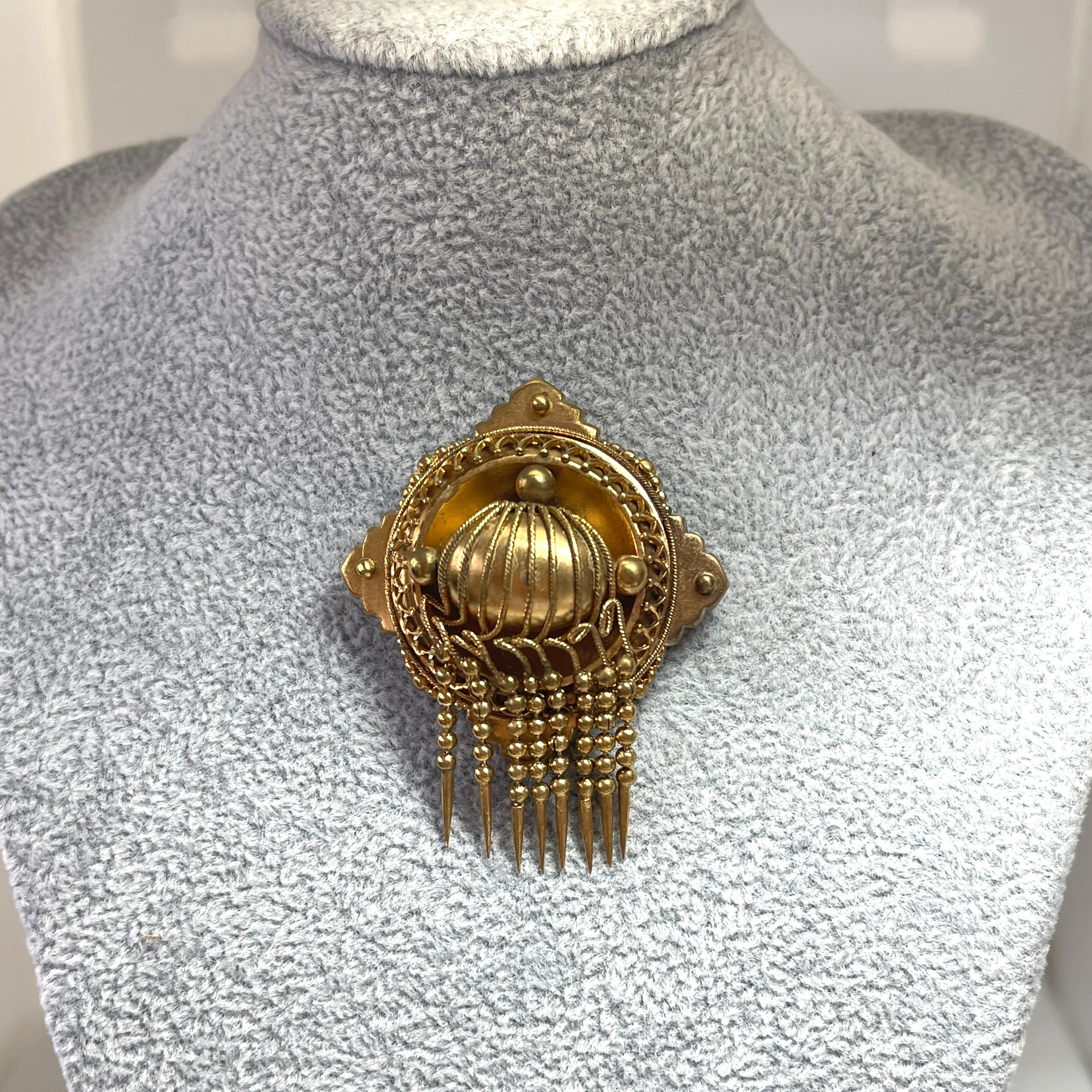 This brooch displays classic, early Victorian style.  
It has been lovingly handmade with delicate cannetille accents.  A tassel fringe dangles elegantly across the bottom of the brooch.  It is so typical of the early Victorian era.
We brought this