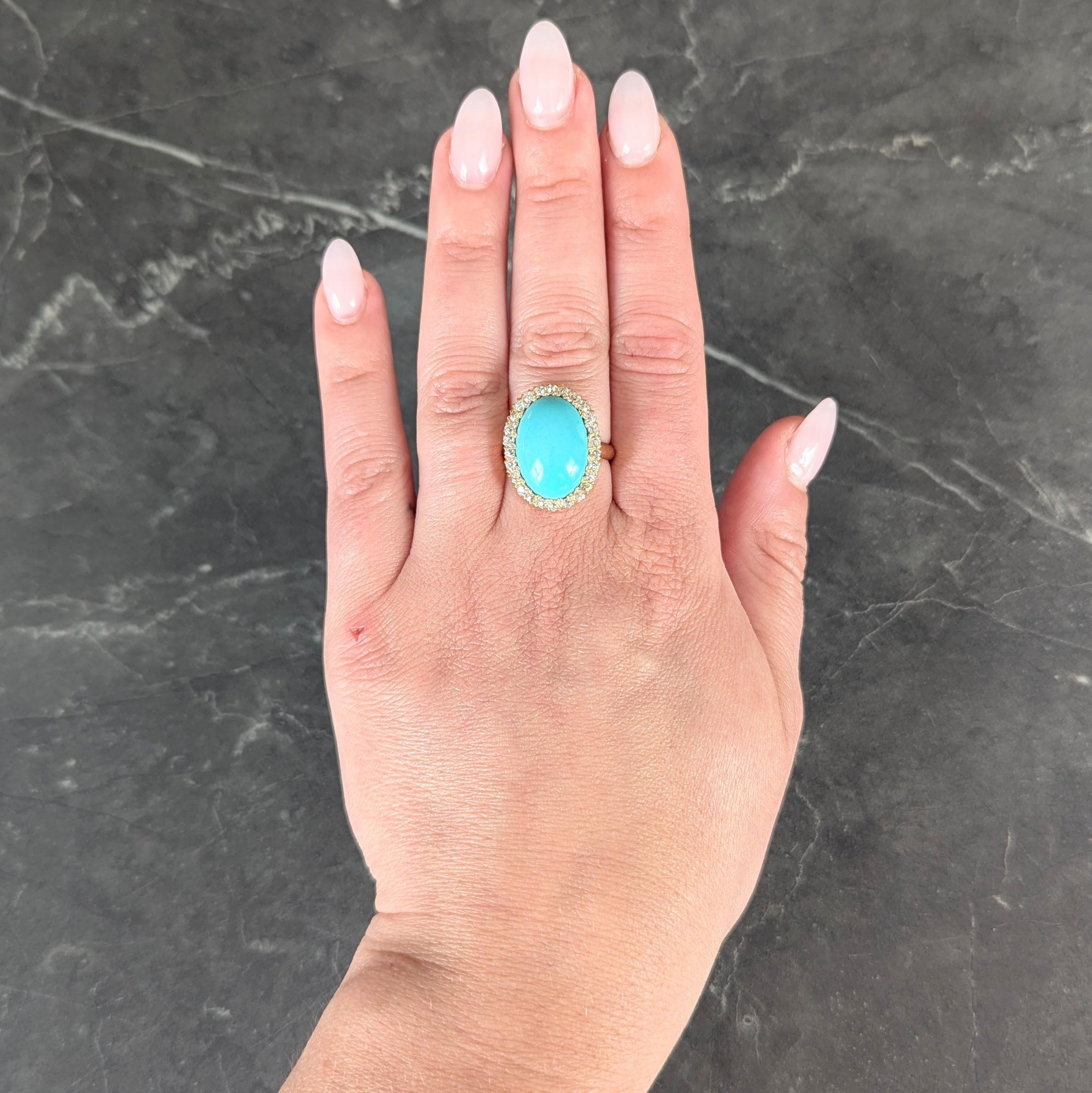 Centering an oval shaped turquoise cabochon measuring 12.5 x 17.5 mm
Opaque light greenish blue in color and bead set with a halo surround
Comprised of old European cut diamonds and set with fishtail prongs
Weighing approximately 1.04 carats