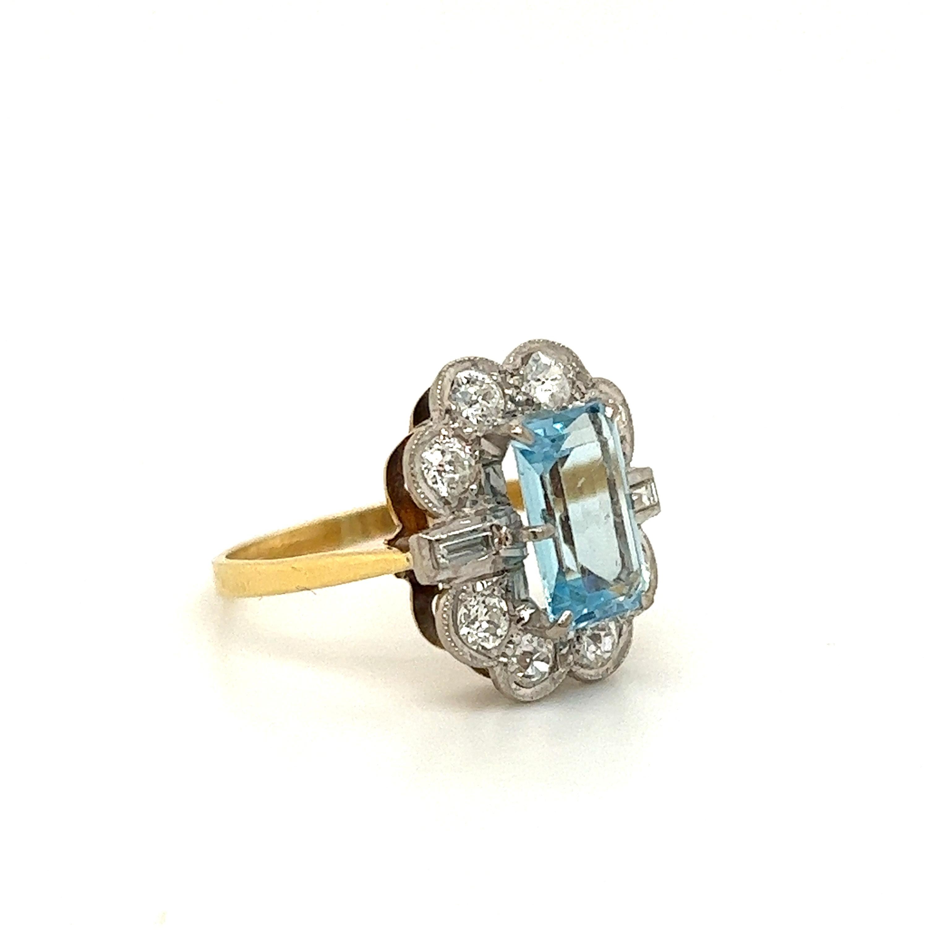 Beautiful design seen on this Victorian treasure. The ring is crafted in platinum and yellow gold. The highlight of the ring is the top half of the design which is set with an aqua marine gemstone and natural earth mined diamonds.  The aqua marine