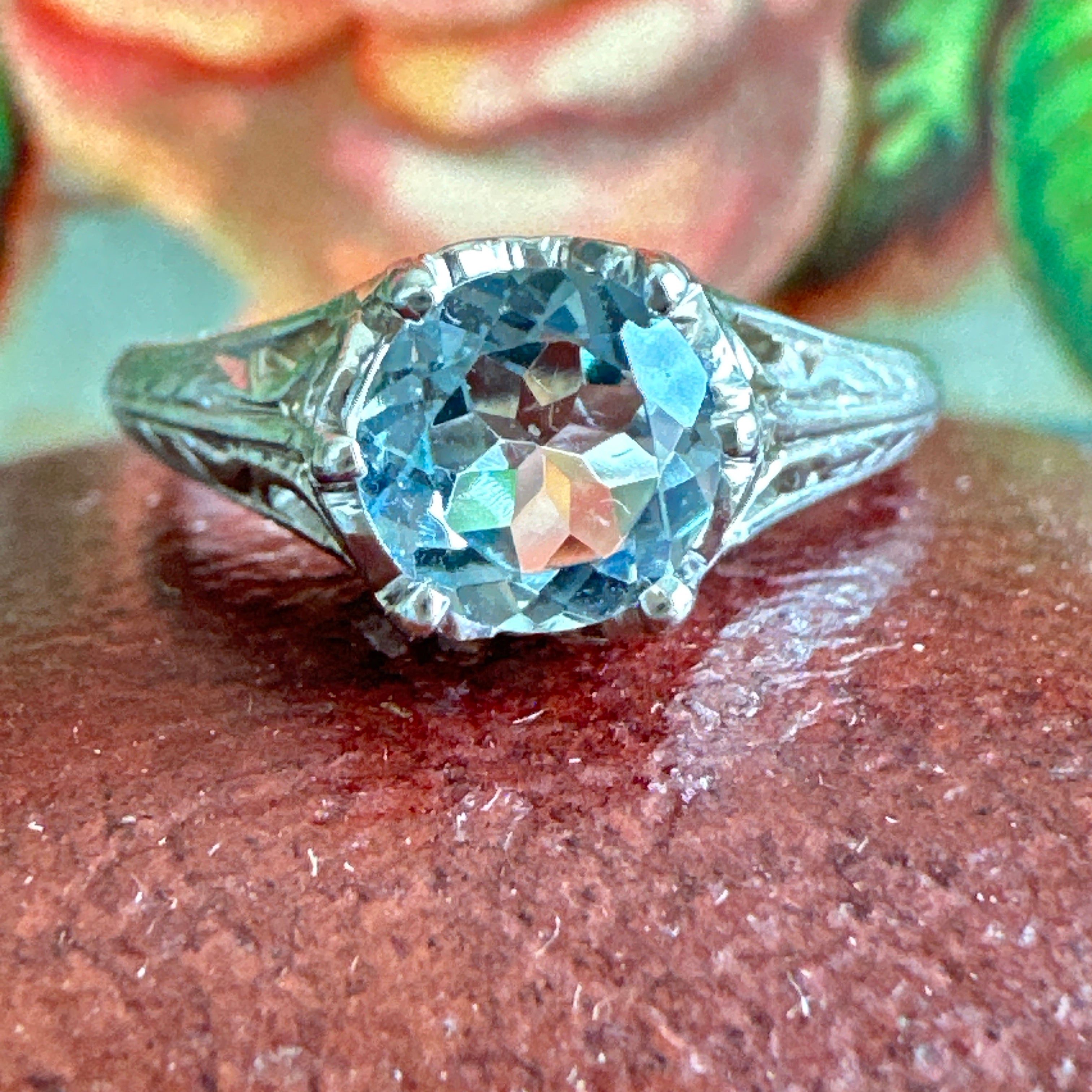 Details:
Beautiful feminine 14K white gold filigree aquamarine ring! The aquamarine measures 5.25mm round, with a classic beautiful blue color. The height from the finger at the center of the aqua is about 5.4mm. The entire front of the setting