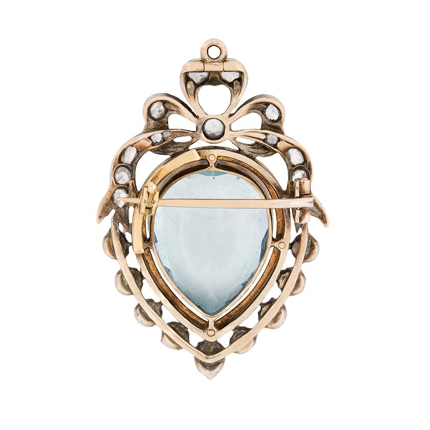 Dating back to the 1880s, this stunning brooch pendant is all handcrafted from 15 carat rose gold and silver. A shining pear shape aquamarine stone steals the show, weighing 10.75 carat and beautifully rub over set. It is surrounded by a boarder of