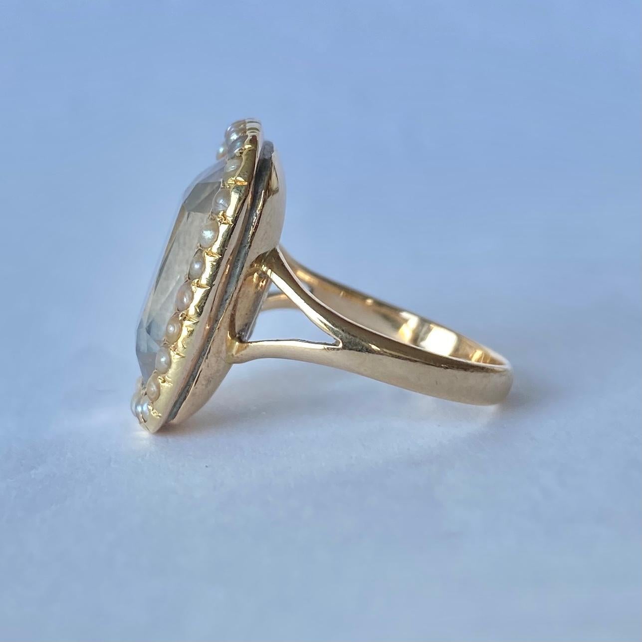 This sweet cluster ring holds a large, pale aquamarine stone and surrounding it is a halo of small pearls. This victorian ring is modelled in 15carat gold.

Ring Size: N or 6 3/4 
Cluster Dimensions: 20x16mm

Weight: 6.6g