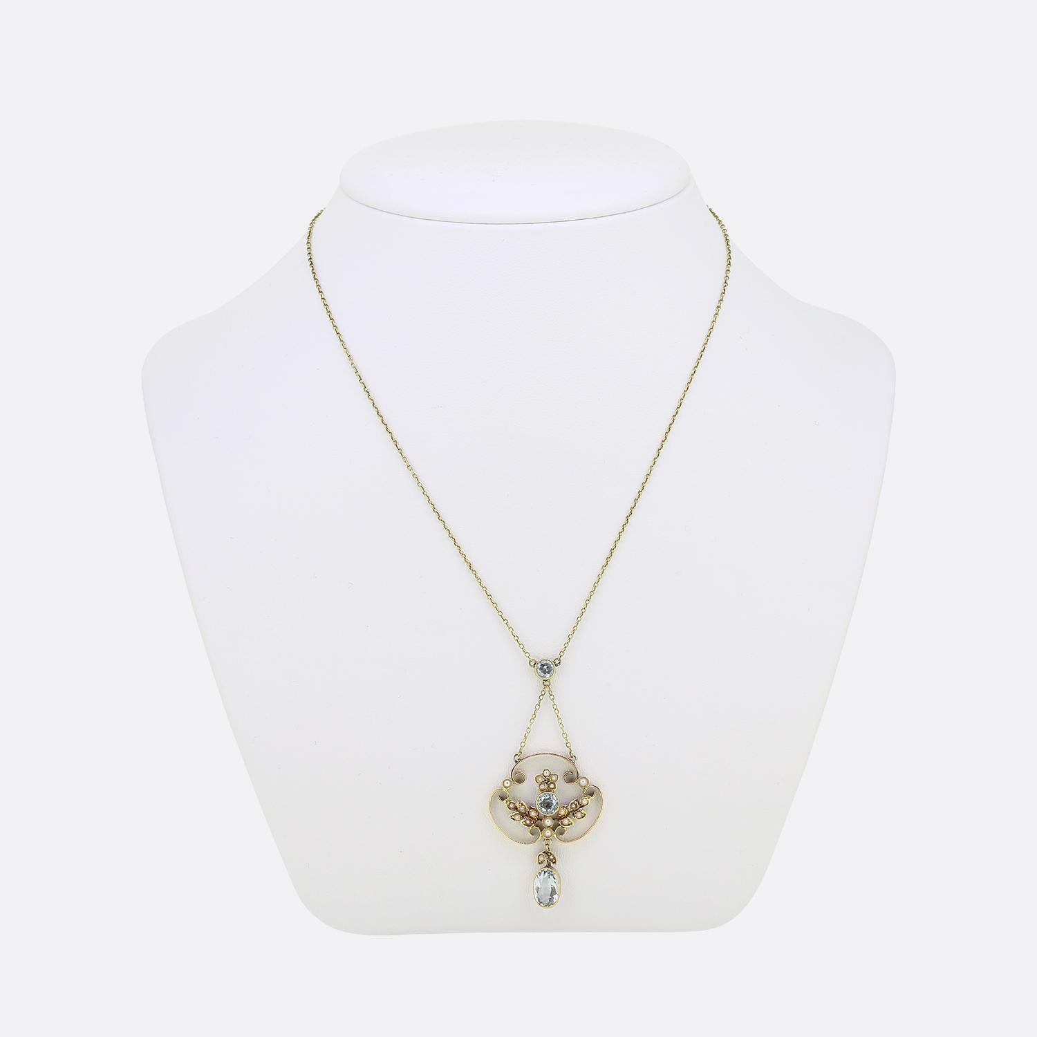 Here we have a charming lavalier necklace dating back to the Victorian era. An open 15ct yellow gold frame is centrally set with a round faceted aquamarine which is surrounded by a fabulous foliated design filled with tiny seed pearls. An oval