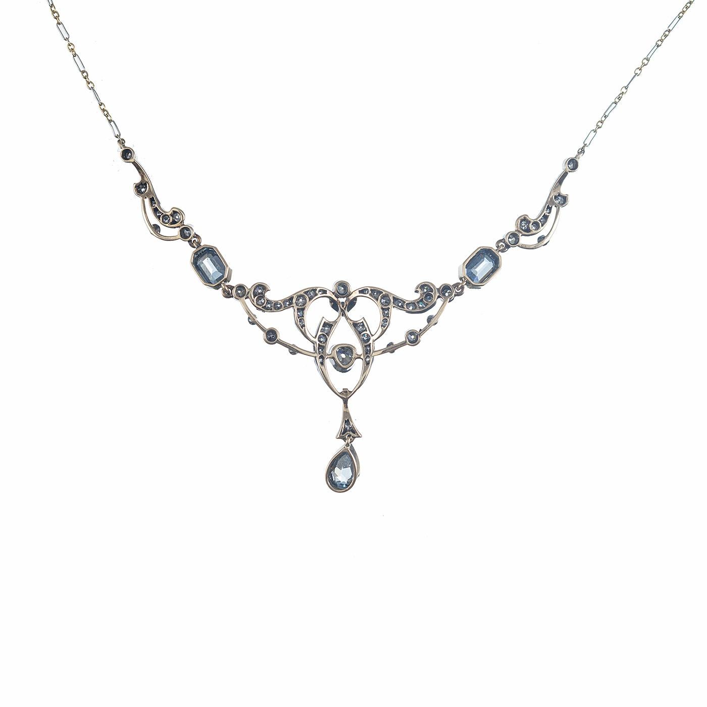 A classic festoon style necklace, oozing Victorian charm with its lacy design centered upon a display of aquamarine and diamonds. Set in silver over gold, the aquamarines weigh approximately 3.00 carats and the diamonds weigh approximately 1.50