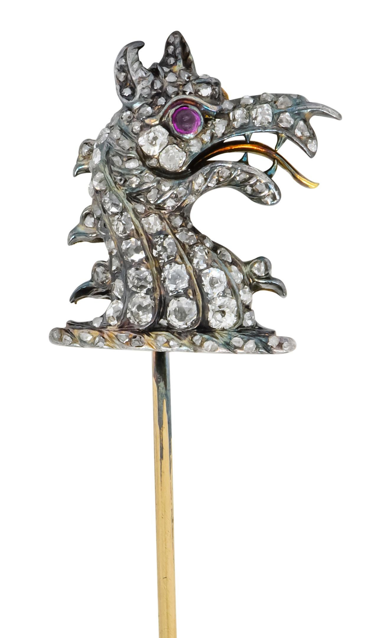 Darstellung eines wilden Drachens mit einem runden Auge aus einem Rubincabochon und einem aufgerissenen Maul mit scharfen Zähnen und einer Reptilienzunge

Perlenbesatz mit Diamanten im Rosenschliff in geriffelten Kanälen, die schuppige Haut