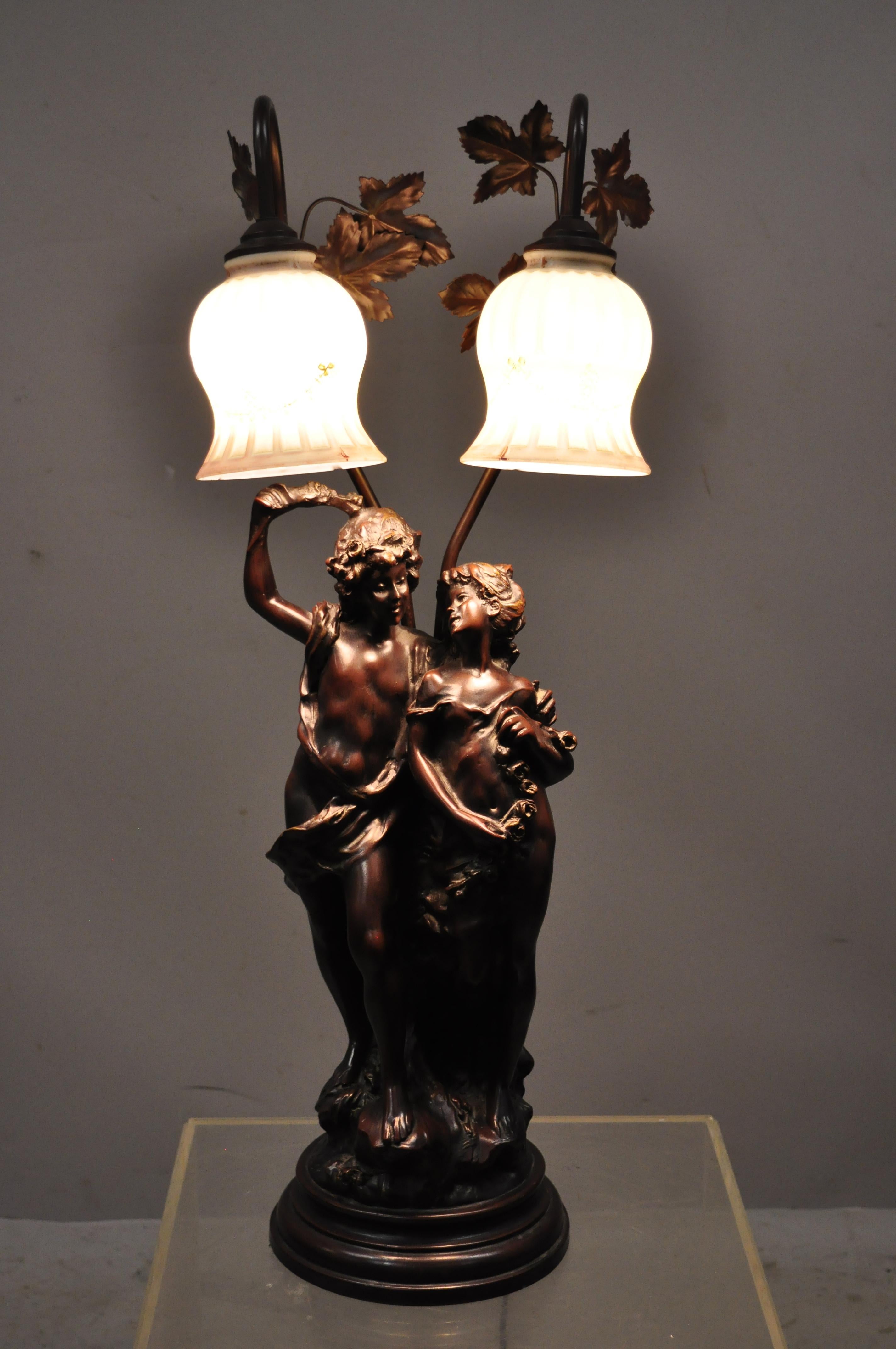 Victorian Art Nouveau French style twin figural male and female metal parlor table lamp. Item features 2 glass floral paint decorated shades, twin male and female figures with remarkable detail, very nice item, great style and form. Believed to be a