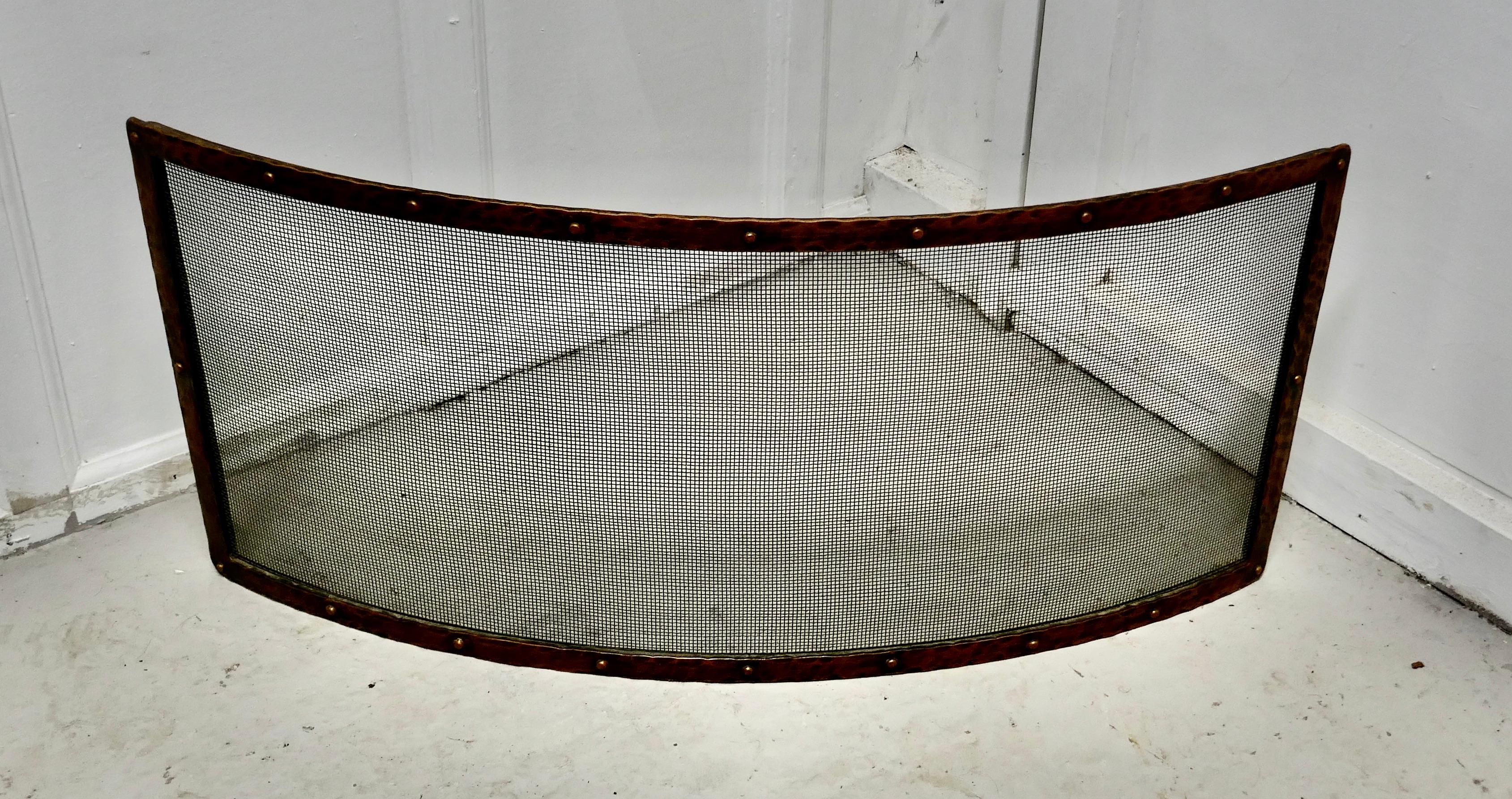 Victorian Arts & Crafts beaten copper curved fire guard, spark screen

The fire guard is a very stylized good quality piece it is made in beaten copper with a fine mesh screen, it is a very unusual but very sensible curved shape.
A delightful