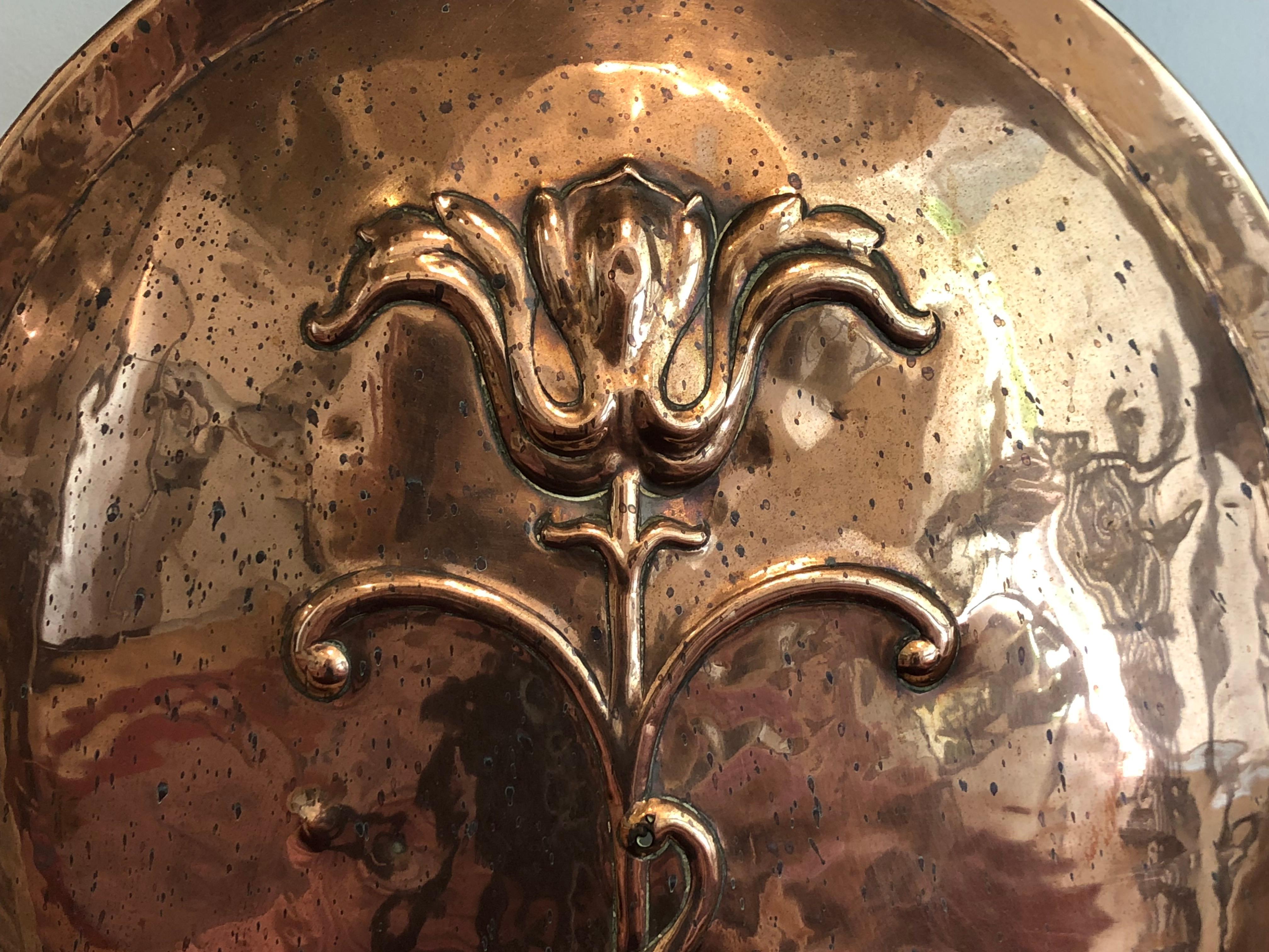 A wonderful copper fire screen in the classic arts and crafts style. 
This screen in hand beaten copper features a large oval with an embossed, stylized flower, the whole surrounded by a hand forged iron frame.
Early 20th century, most probably