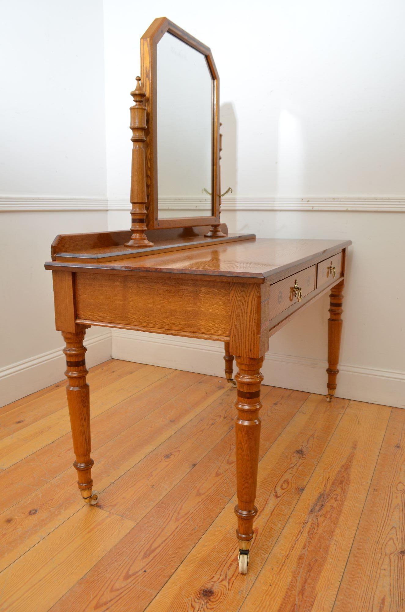 R044 Quality Victorian Aesthetic movement inlaid ash dressing table with original foxed adjustable mirror, supported by inlaid turned columns, with attractive finials.
The solid ash top has chamfered inlaid edges and sits above two inlaid drawers