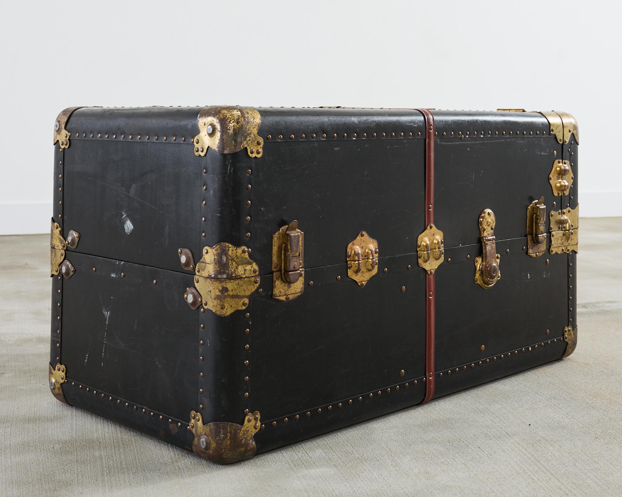 Large Victorian wardrobe standing steamer trunk made by Atkinson and Long, New York. The trunk features a dramatic black exterior finish accented by red banding in the style of early Louis Vuitton French motoring trunks. Very heavy and solid hard