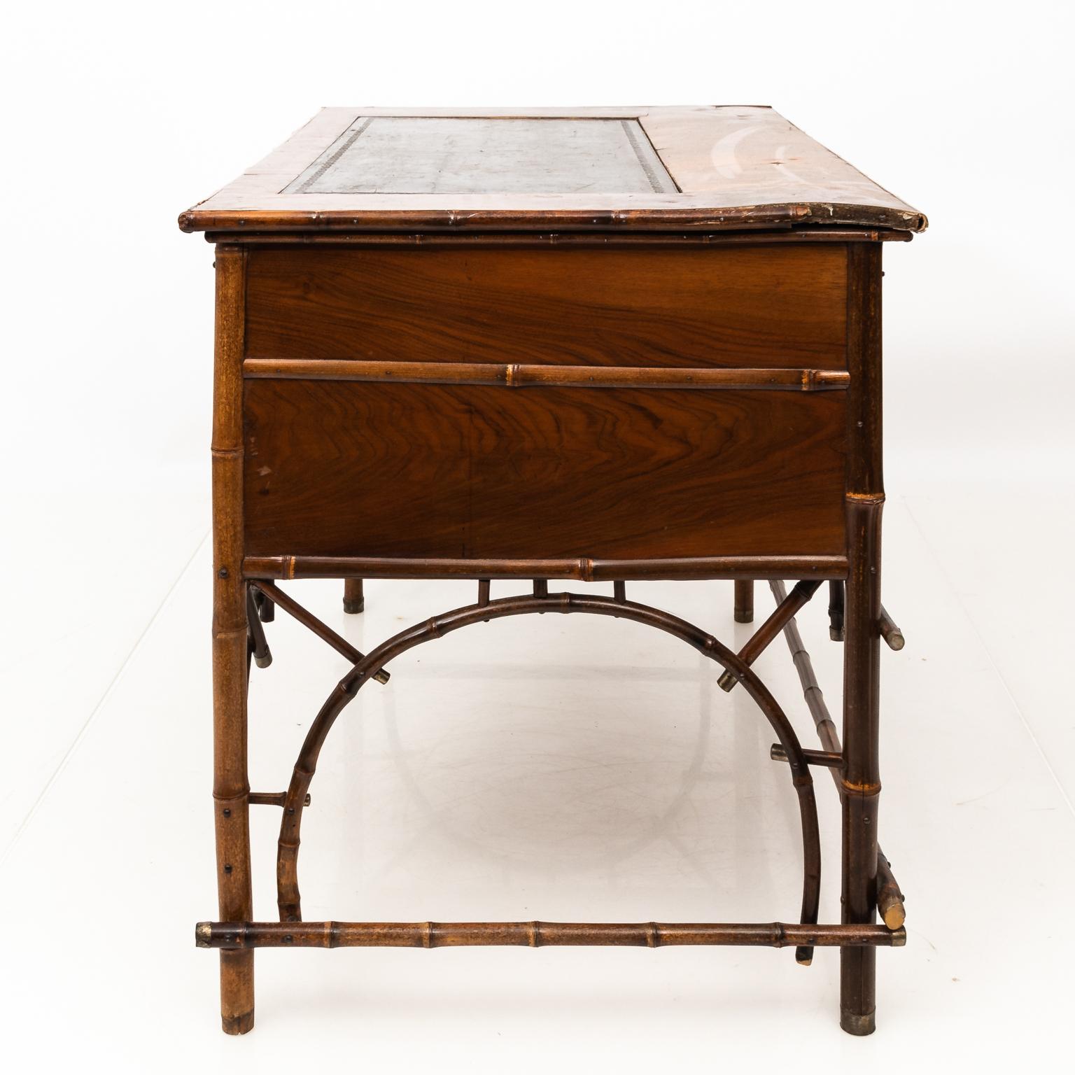 Faux bamboo and leather top Chinoiserie style writing desk with five drawers and original brass hardware, circa late 19th century.
     