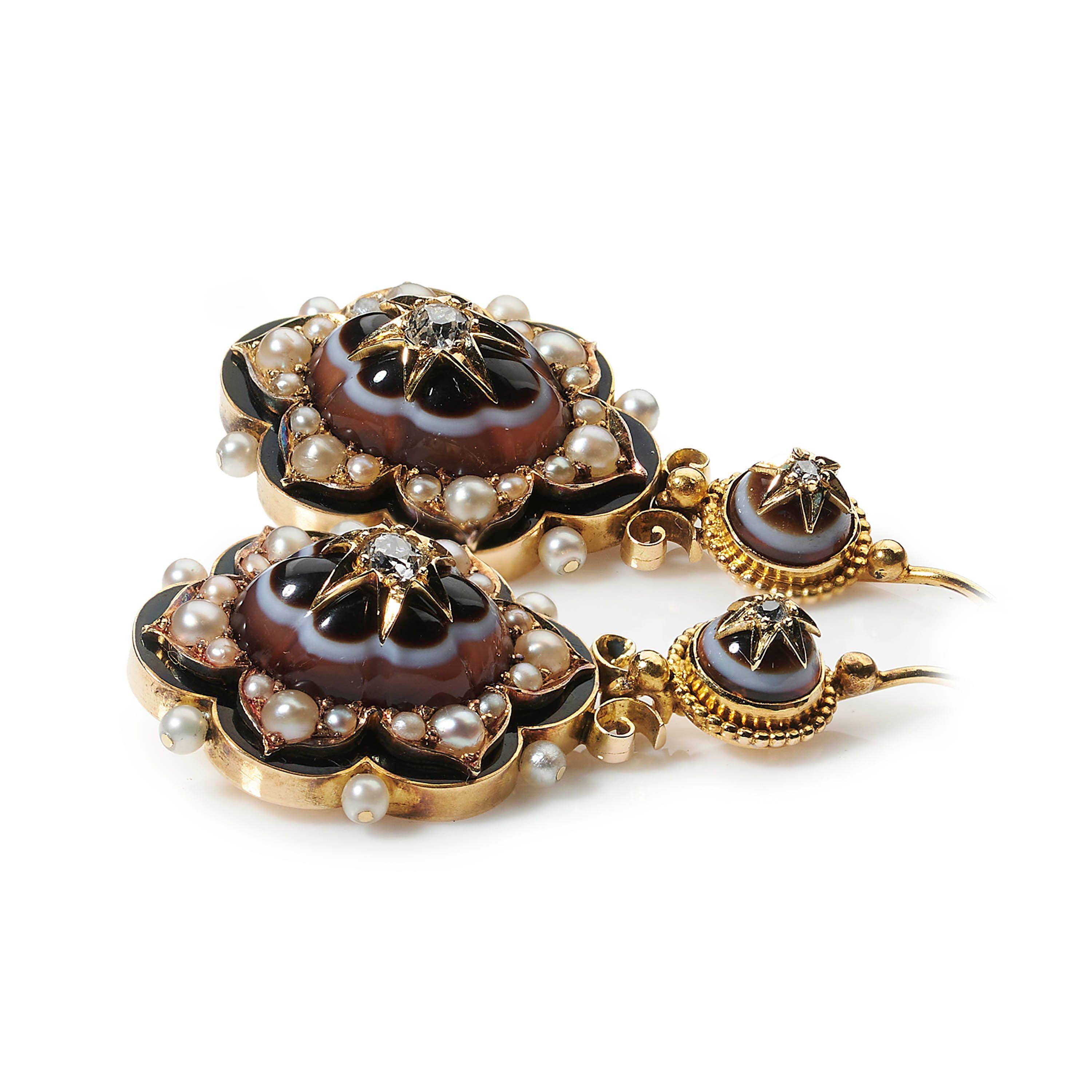 A pair of Victorian banded agate, natural pearl, diamond, enamel and gold drop earrings, with old-cut diamonds in the centre of the pendants, on gold star settings, on carved, fluted banded agate, surrounded by groups of three natural half seed