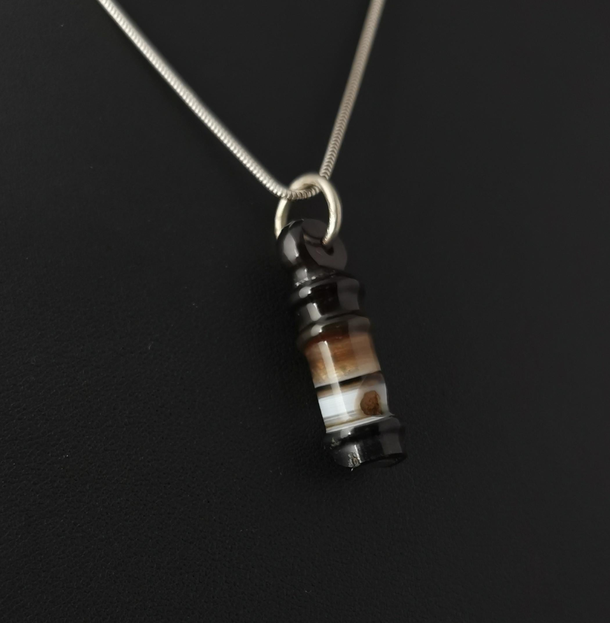 A gorgeous and fun little antique, Victorian era banded agate whistle pendant.

Beautiful banded agate in tones ranging from black to white all hand carved and polished to form a perfect miniature whistle!

The pendant comes on a later sterling