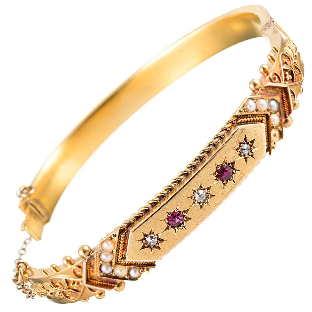 Ever popular theme in Victorian times, the oval-shaped bangle can be “stacked” with your other favorites or stand alone. Decorated with Etruscan granulation, diamonds, rubies and pearls, this piece, rendered in 15k yellow gold, has been beautifully