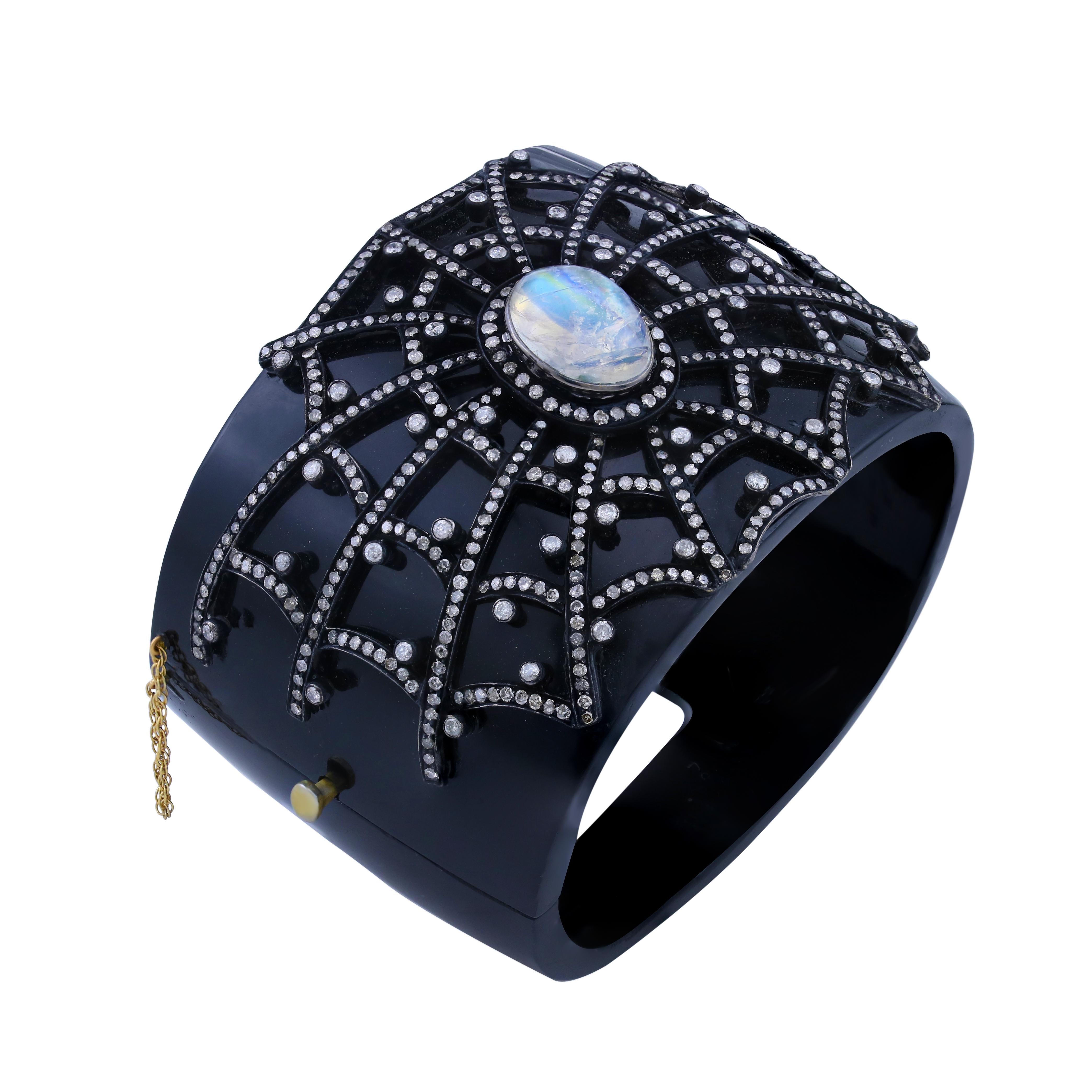 Introducing our stunning Bangle with Black Onyx, Rainbow Moonstone and Diamond Bangle in 14K/925 Silver! The body of this bangle is made of black onyx, with a beautiful oval rainbow moonstone in the center, surrounded by a spider web of diamonds.