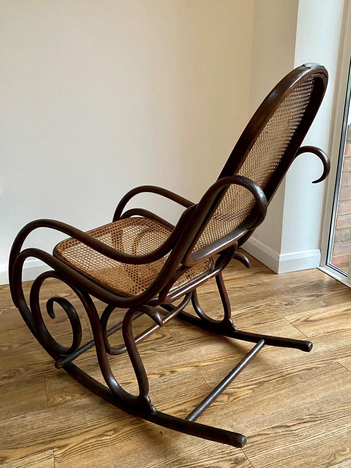 A bentwood and cane rocking chair by Thonet. Having the Thonet trademark beautiful flowing organic form. The cane is in good condition and solid. The chair has good color and wear is consistent with its age and use. Having an engraved plaque to the