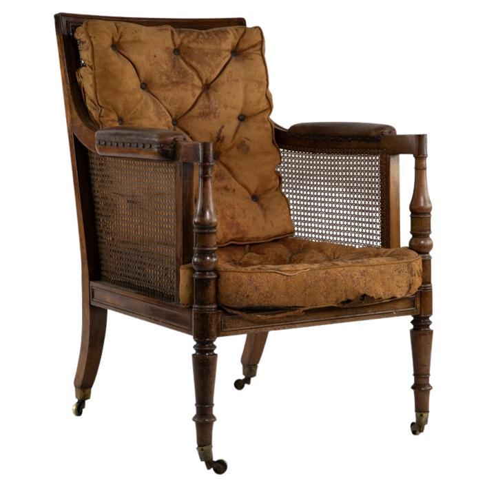  Bergere  Chair with original leather cushions, brass castors, caning on sides in excellent condition. 