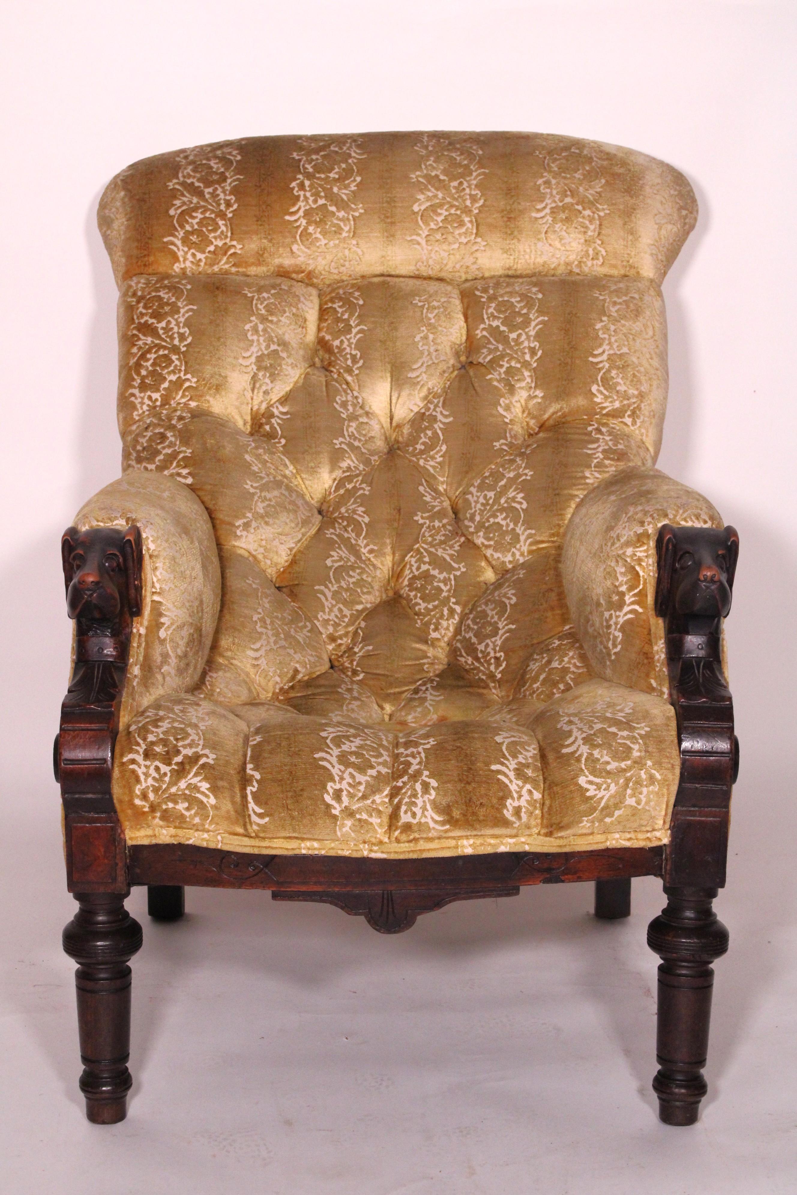 English Victorian mahogany bergere with arms ending in carved hound heads, circa 1880. With button and tuck upholstered back and seat, arms ending in carved hound heads, turned and tapered front legs. Very comfortable chair to sit in.