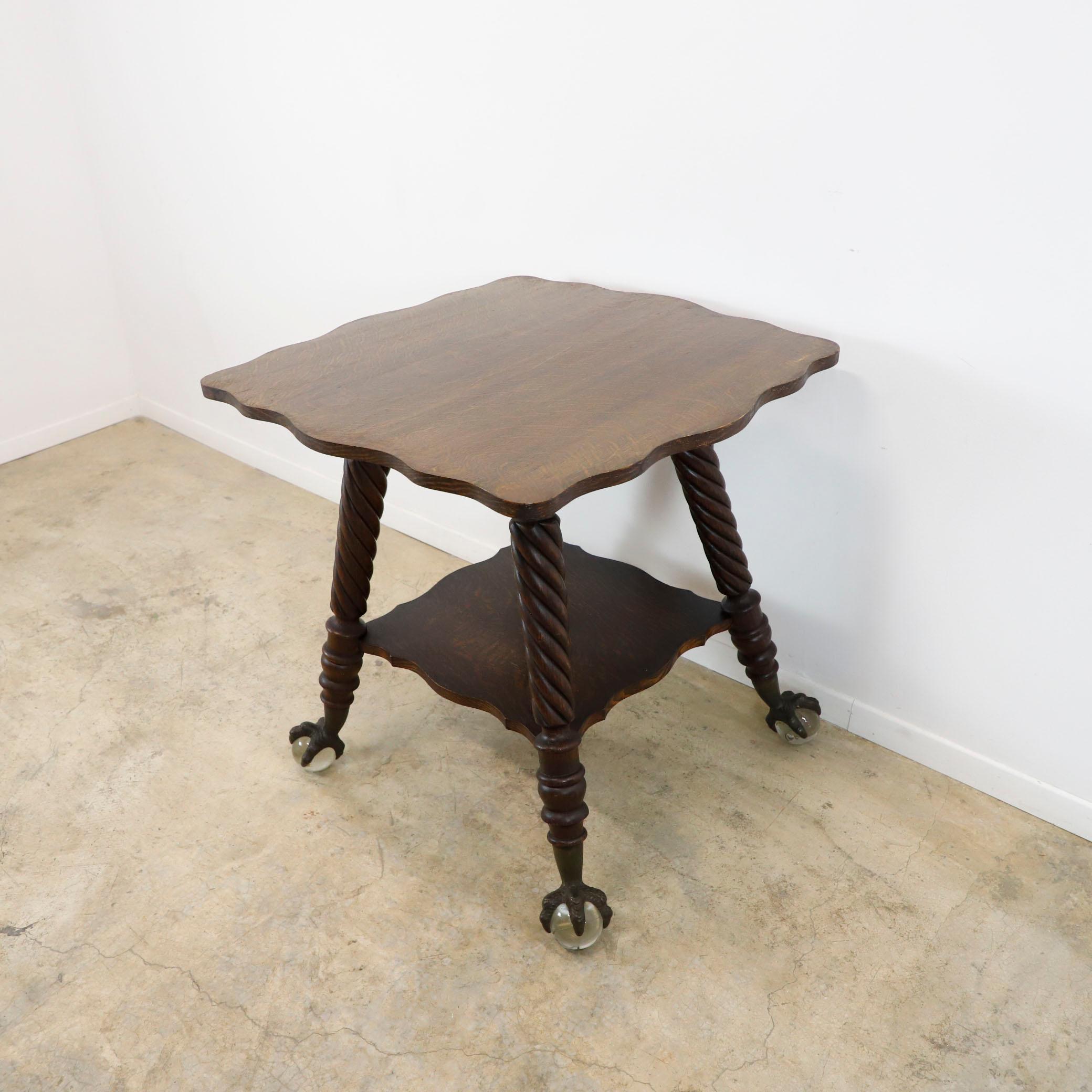 Table victorienne Bigli en verre à boule et à griffes en chêne, vers les années 1920.
Magnifique table d'appoint avec pieds en fuseau tournés. Il y a 4 griffes d'aigle en fer qui tiennent des boules de verre pour les pieds de grande taille.