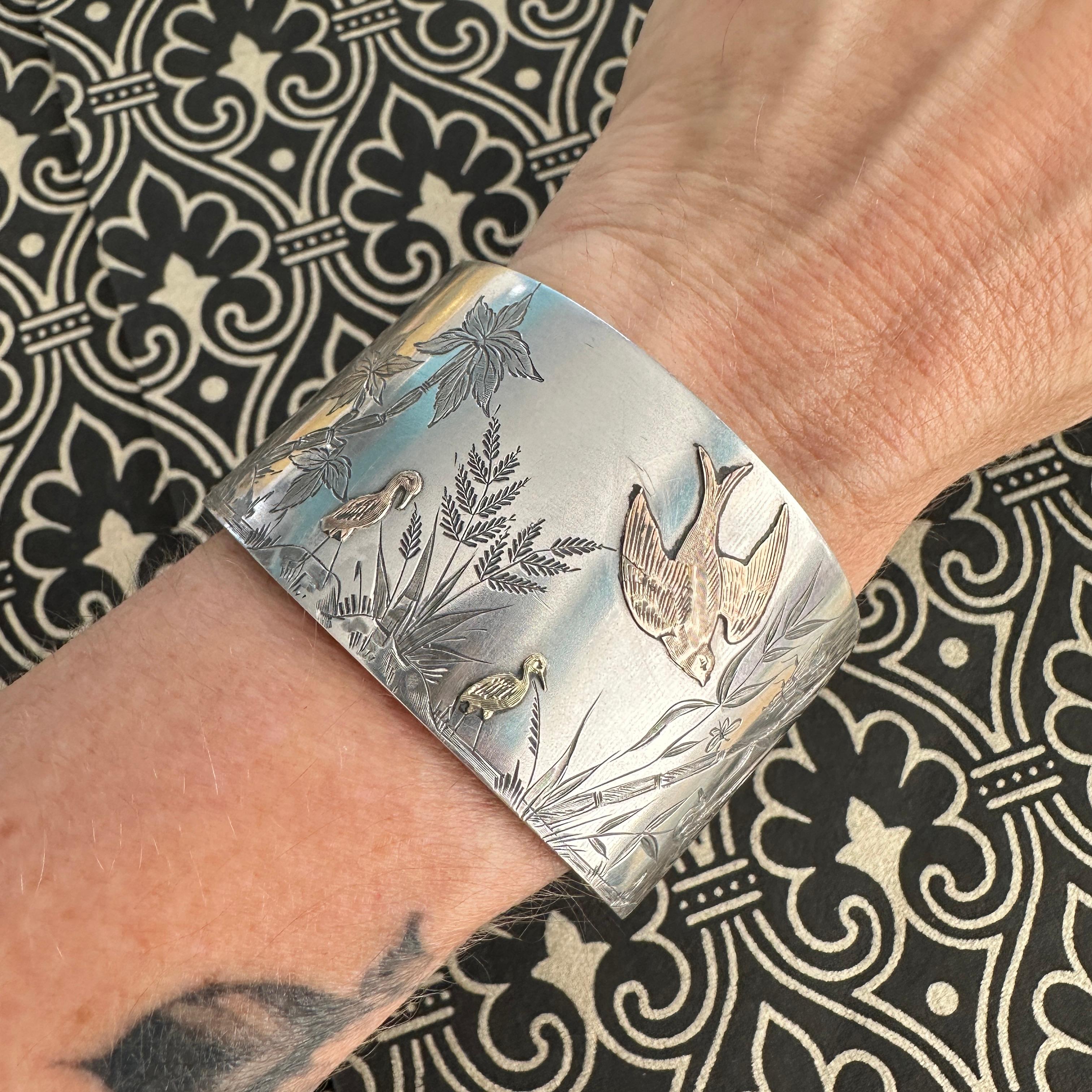 Details:
Beautiful Aesthetic movement European Victorian sterling silver, yellow and rose gold bird and bamboo pattern bracelet. The details on this piece are lovely, with a large rose gold bird, two smaller gold birds and lovely engraved reeds and