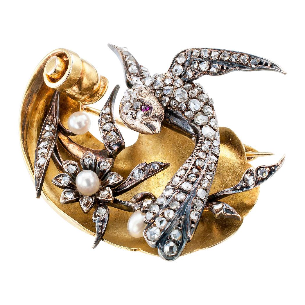 Victorian bird brooch set with diamonds pearls and a ruby mounted in silver and gold circa 1880. The handcrafted design depicts a pheasant entirely set with rose-cut diamonds and a ruby-set eye gracefully flying over a delicate, flowering branch