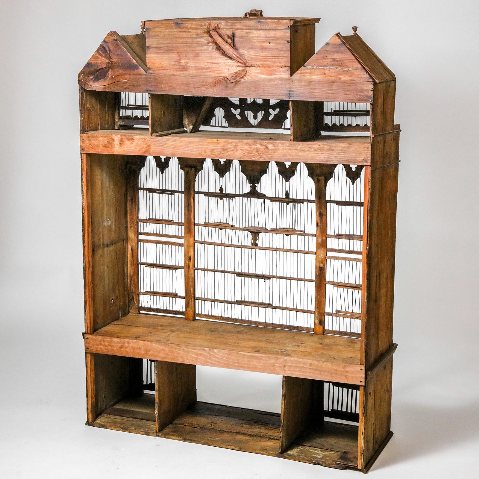 A large five foot high late 19th century bird house with gabled roof and many open doorways. No backpiece.