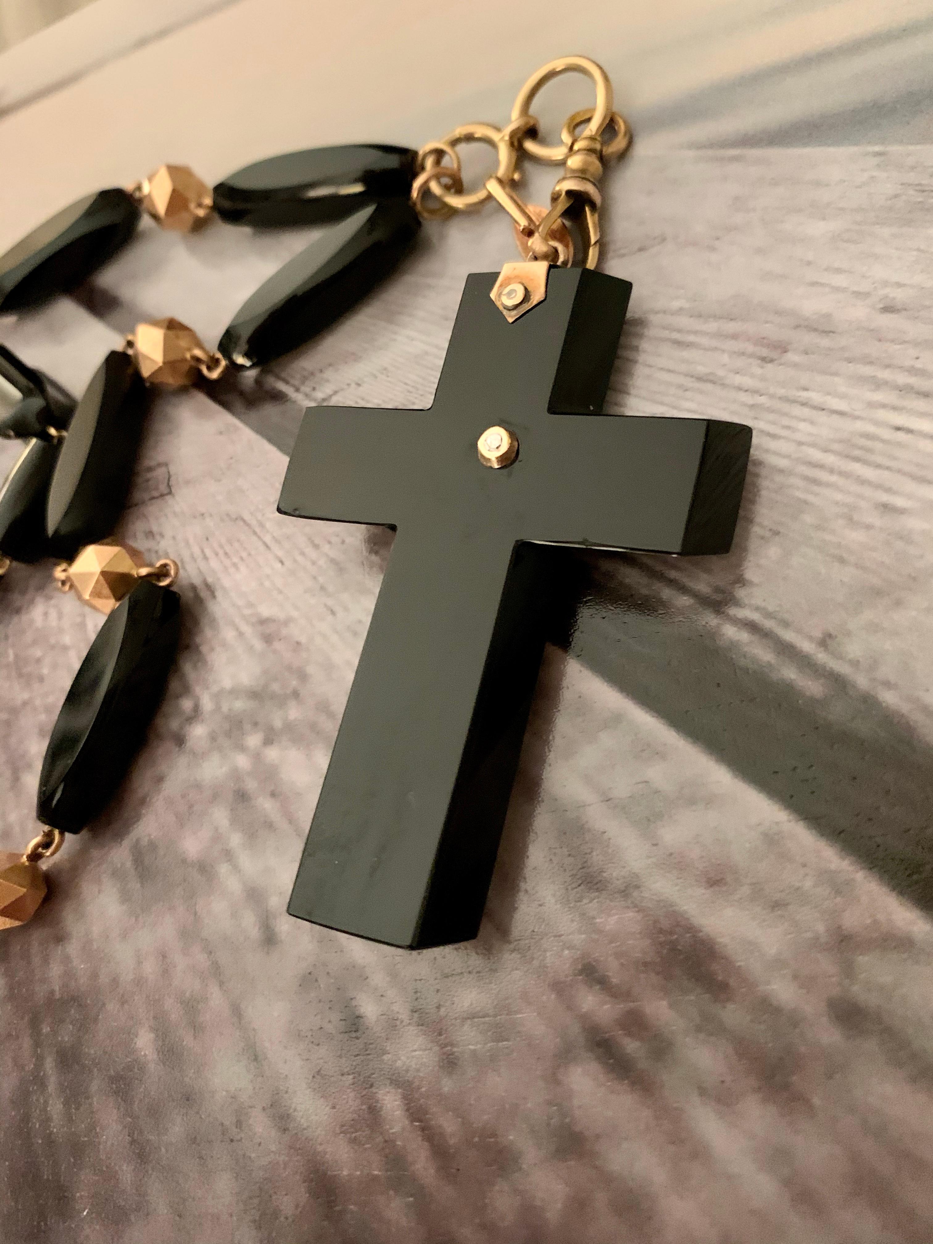 This Victorian cross is made from black Onyx and features a silver floral design on top of the cross.  The cross hangs from a 14 karat yellow Gold and black onyx bead chain.  The cross is removable from this chain so the chain may be worn alone or