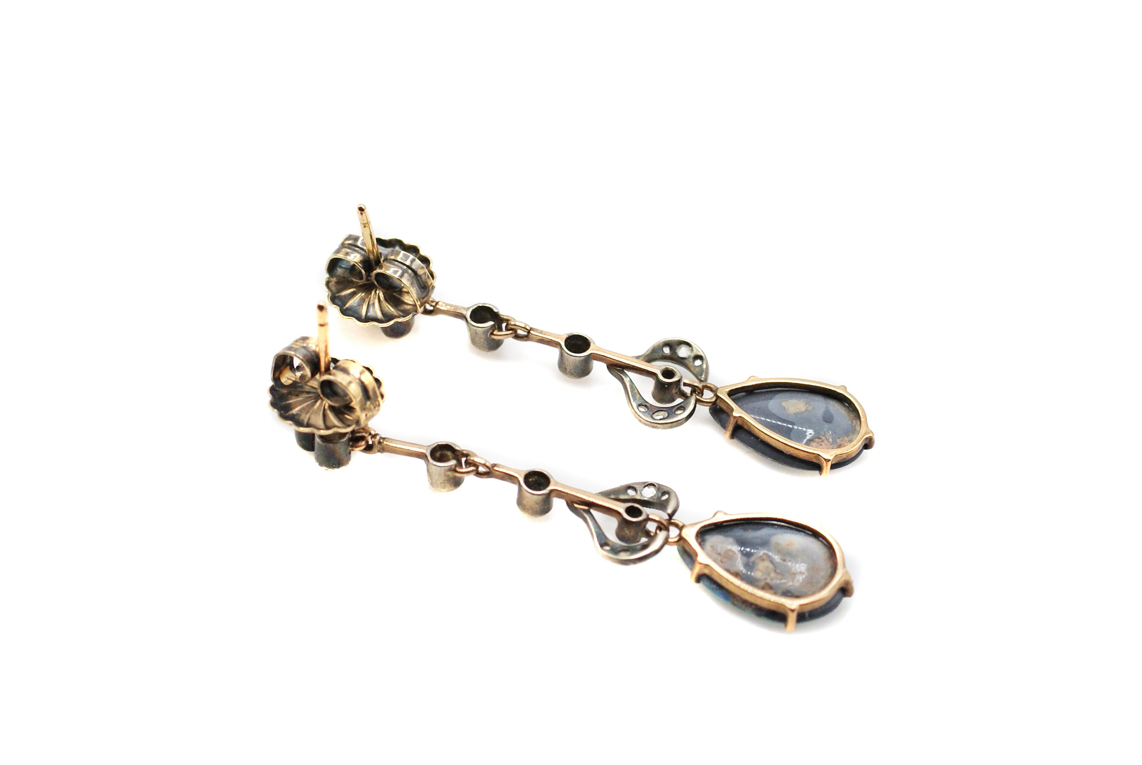 These unique Victorian earrings, handcrafted out of silver topped rose gold, are set with 2 pear shape extremely rare black opals, displaying all colors from blue, green, orange, and fiery red. The perfectly matched black opals, measured to weigh
