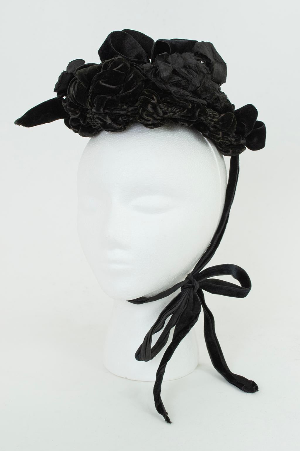 Worn during the Victorian lady’s two-year mourning period, this petite hat telegraphed propriety and solemnity without sacrificing style. Featuring a stiff skullcap adorned with silk velvet bows and gathers, it is accentuated by silk ribbon roses.