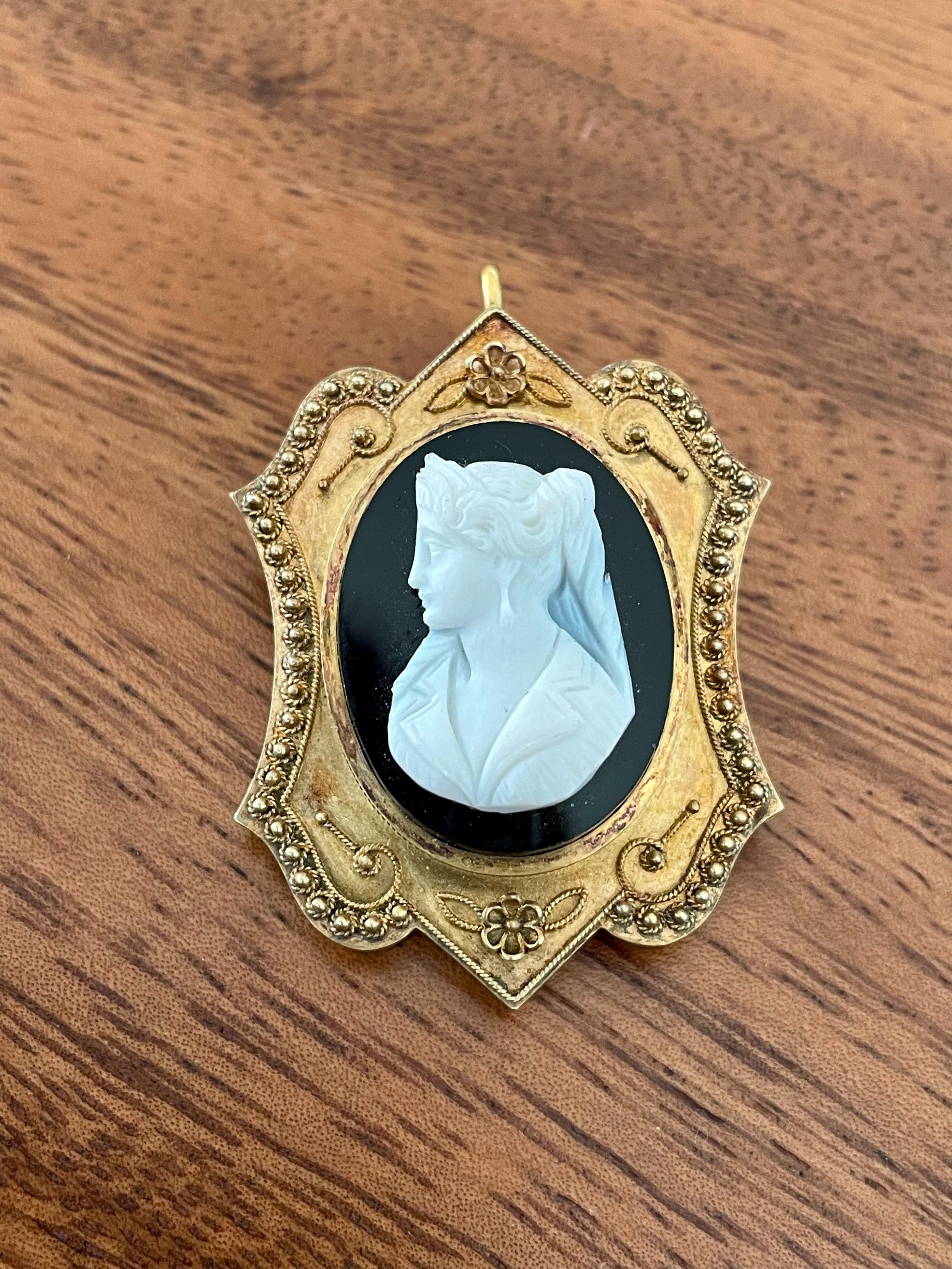 This Victorian cameo is carved from black and white hard stone agate.  It is set in 14 karat yellow Gold.  It can be worn as a pendant or as a brooch.  (Chain shown is shown for photos only and is not included in the sale price).

Weight:  10.5