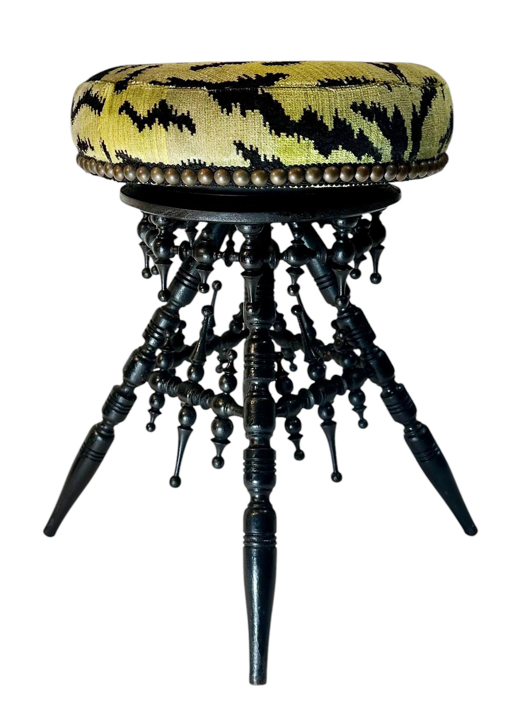 A striking Victorian era black wood stool, beautifully upholstered in luxurious Italian Scalamandré tiger velvet. The bold, iconic fabric contrasts elegantly with the deep black wood frame, showcasing the dramatic flair and refined craftsmanship of