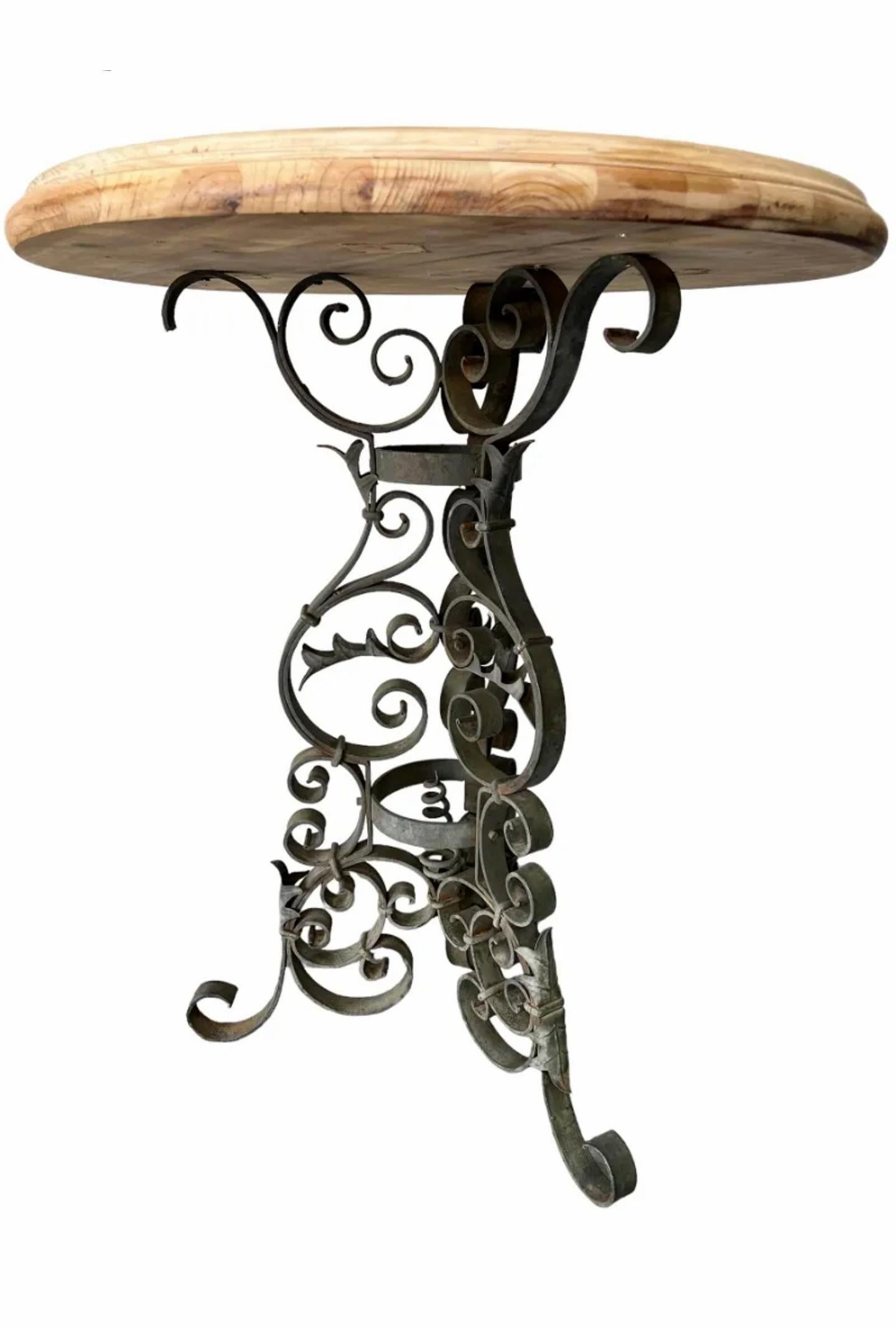 Table de bistrot antique de l'époque victorienne, 19e siècle, avec un plateau rond en bois blanchi à bord mouluré, reposant sur un socle tripartite en fer forgé noir orné de volutes. 

Dimensions : (environ)
36,5