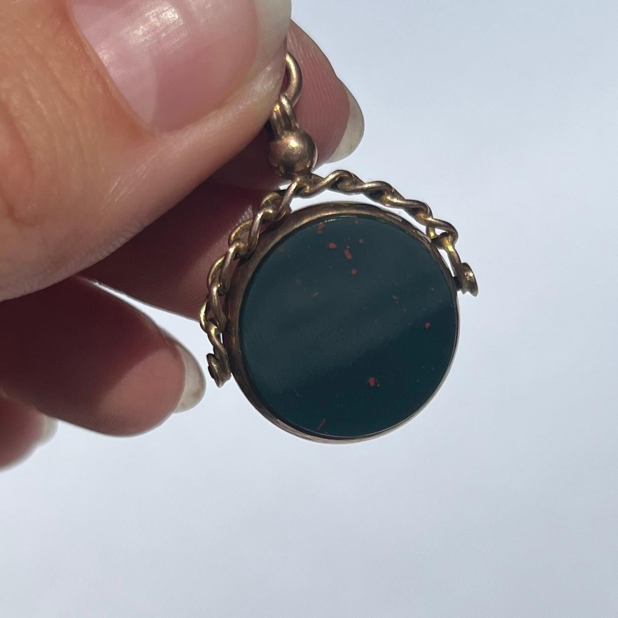 This classic 9ct gold fob holds a carnelian and bloodstone that spin! The gold work above the stones are ornate and resembles chain links. 

Stone Diameter: 18mm 
Height From Loop: 33mm

Weight: 6.5g




