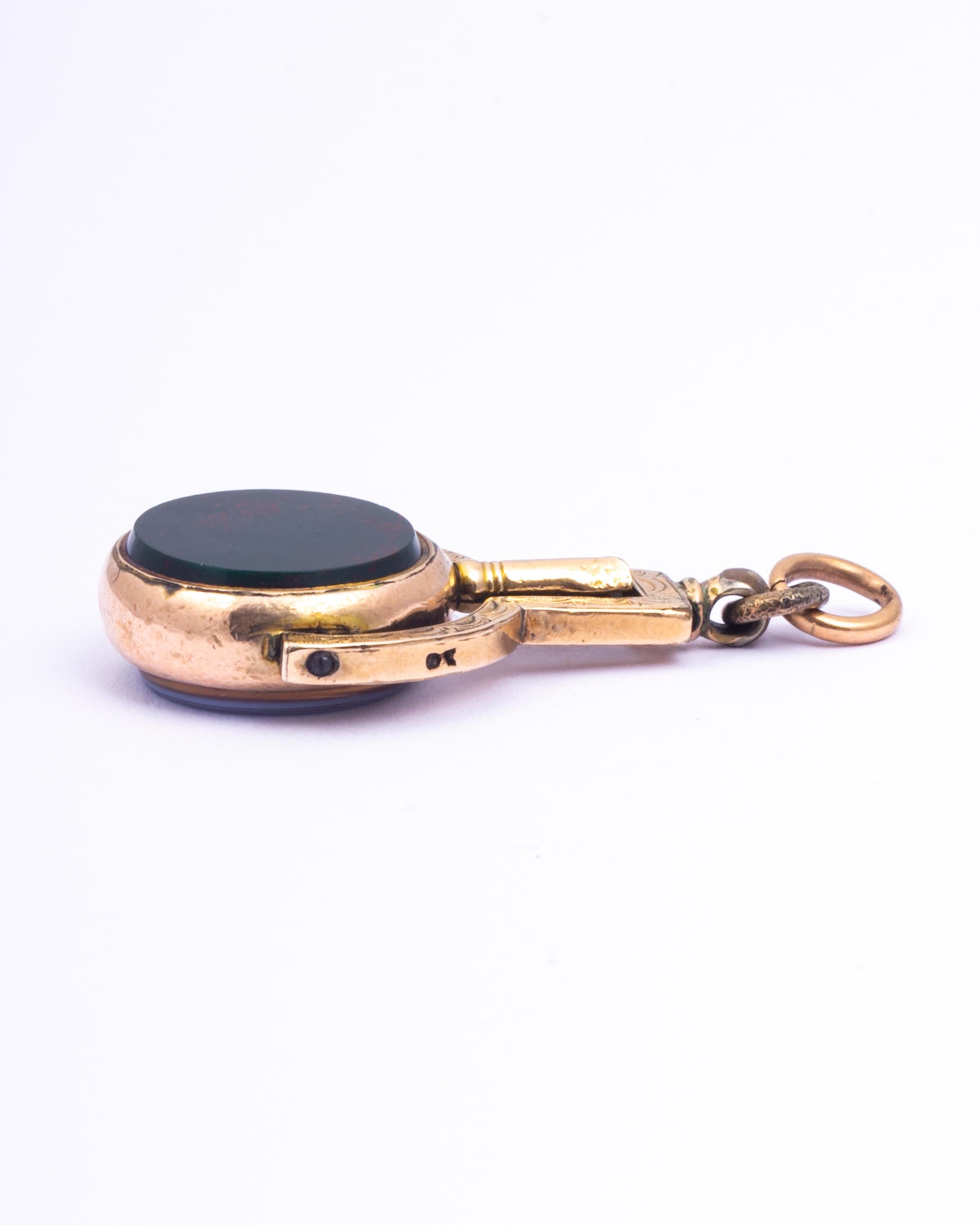 This classic 9ct gold fob holds a sardonyx and bloodstone but the unusual element is that it is actually a watch key! As you can see the fob spins and reveals the watch key. 

Stone Diameter: 16mm  
Fob Length From loop: 41mm 

Weight:8.4g



