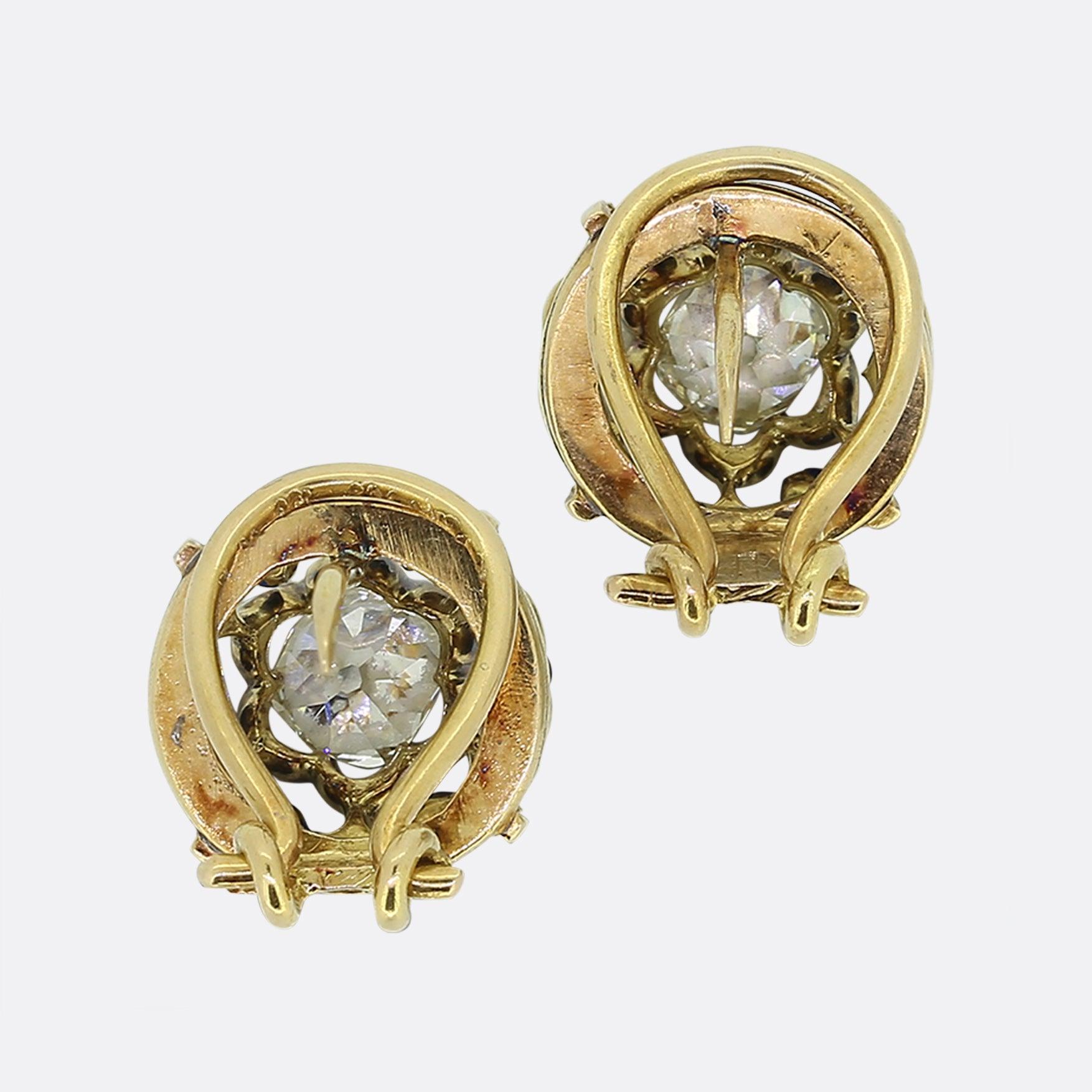 Here we have a delightful pair of diamond earrings from the Victorian era. Each antique piece is identical and presents an open undulating double frame which surrounds an impressive chunky old mine cut diamond. This focal stone is then circulated