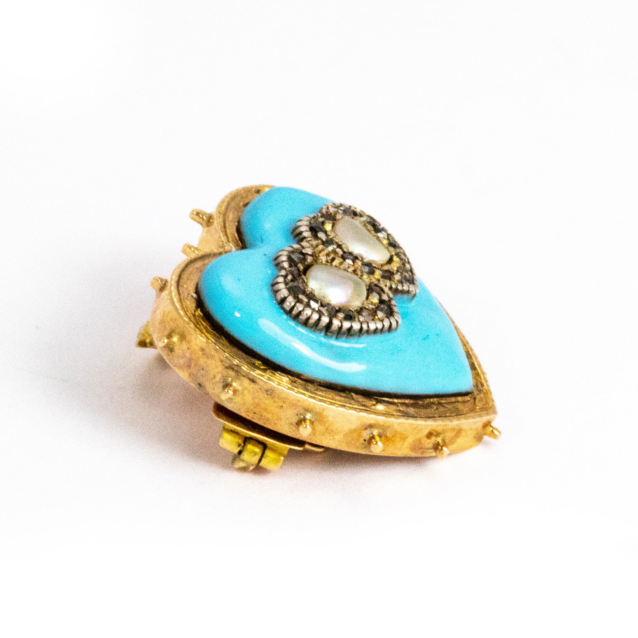 A glorious Victorian heart pendant modelled in 15 karat yellow gold and fronted with rich light blue enamel. The two entwined heart motifs on the front are lined with rose cut diamonds and centred with mother of pearl. The pendant hook is set with