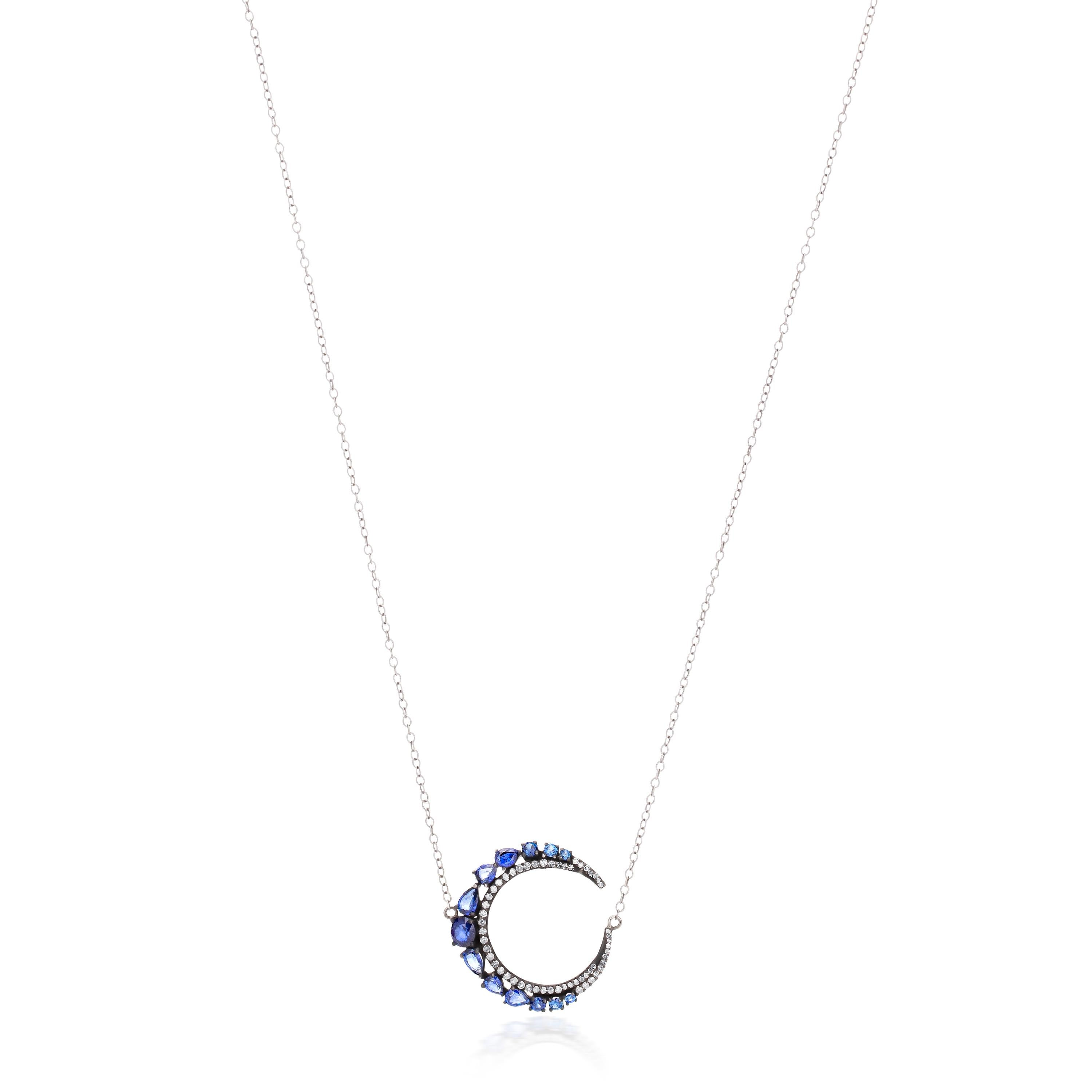 Charms of the moon! A Victorian blue sapphire and diamond crescent pendant, set with round and pear, faceted blue sapphire, on top of a crescent row of pave set round diamonds mounted on 925 sterling silver and 18k gold. The pendant is stationed