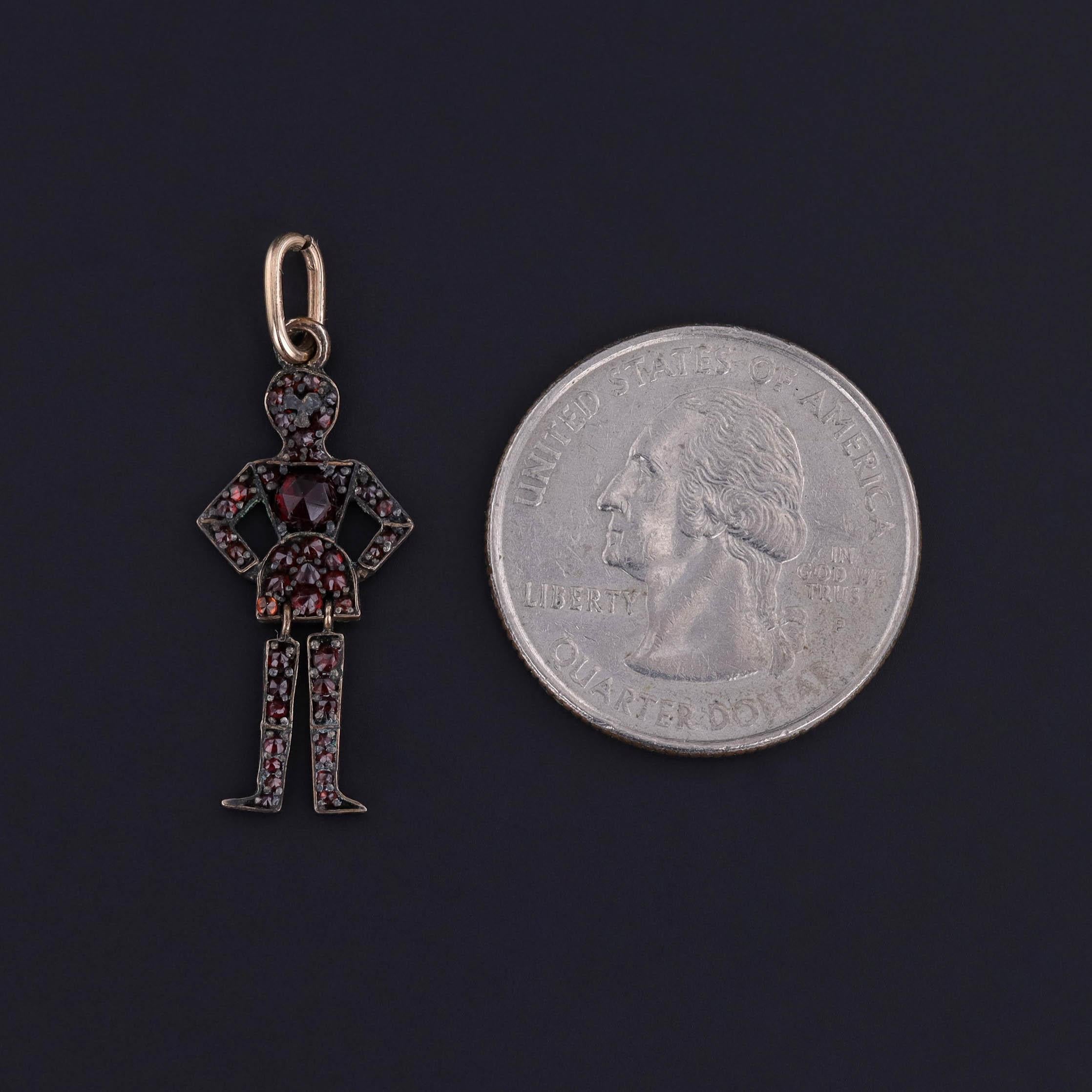 Un antico charme mobile di epoca vittoriana (circa 1870-1890), con una persona di granati boemi rosso scuro. Le gambe penzolano, dando al charme un movimento fluido.

Il pezzo misura 1,3 pollici dalla parte superiore della cauzione a quella
