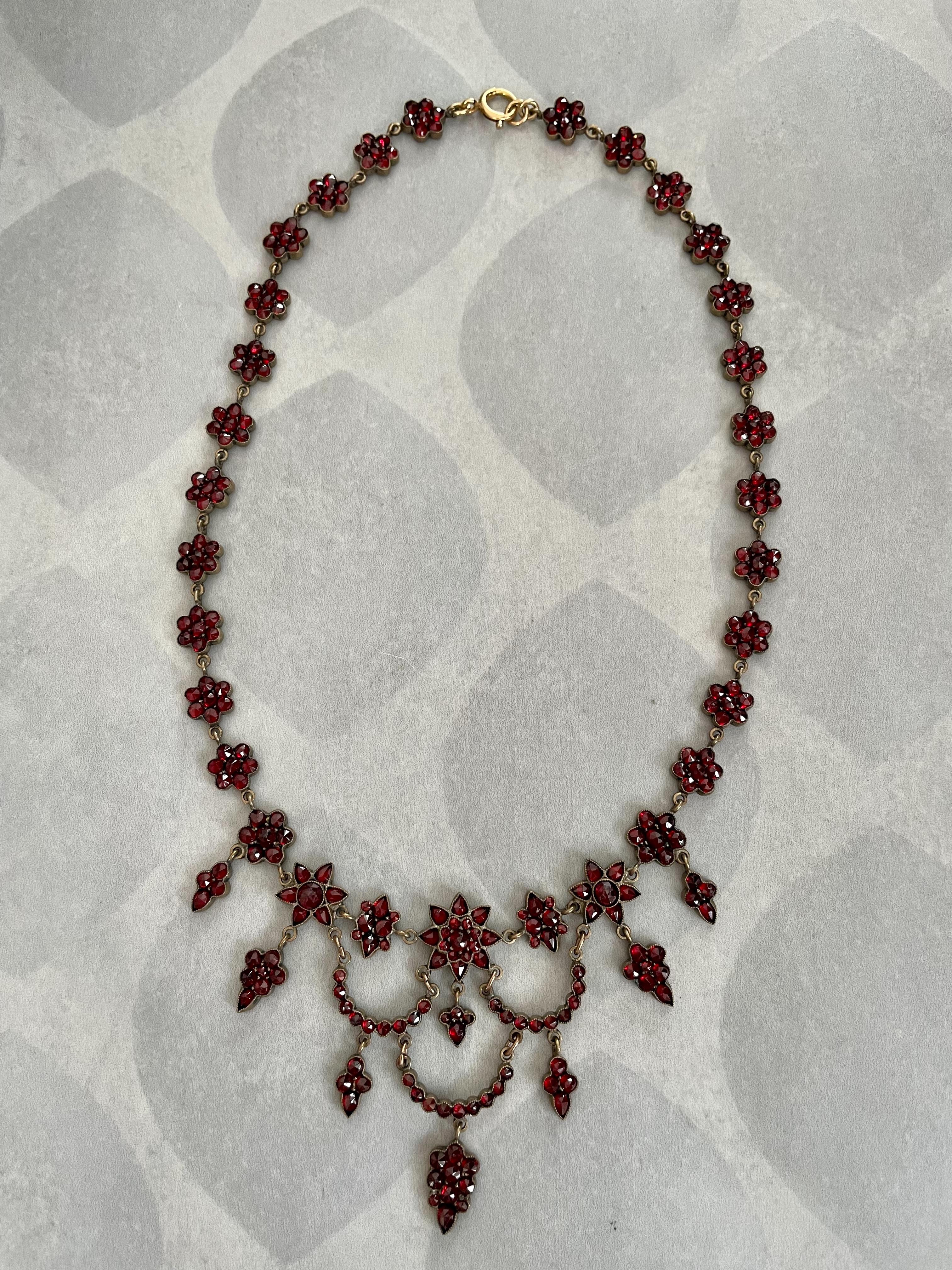 This beautiful Victorian cluster necklace is generously adorned with rose cut Bohemian Garnet.  The setting is Gold Filled.

Stamp:  1/20 12k GF

Necklace length:  16 1/2