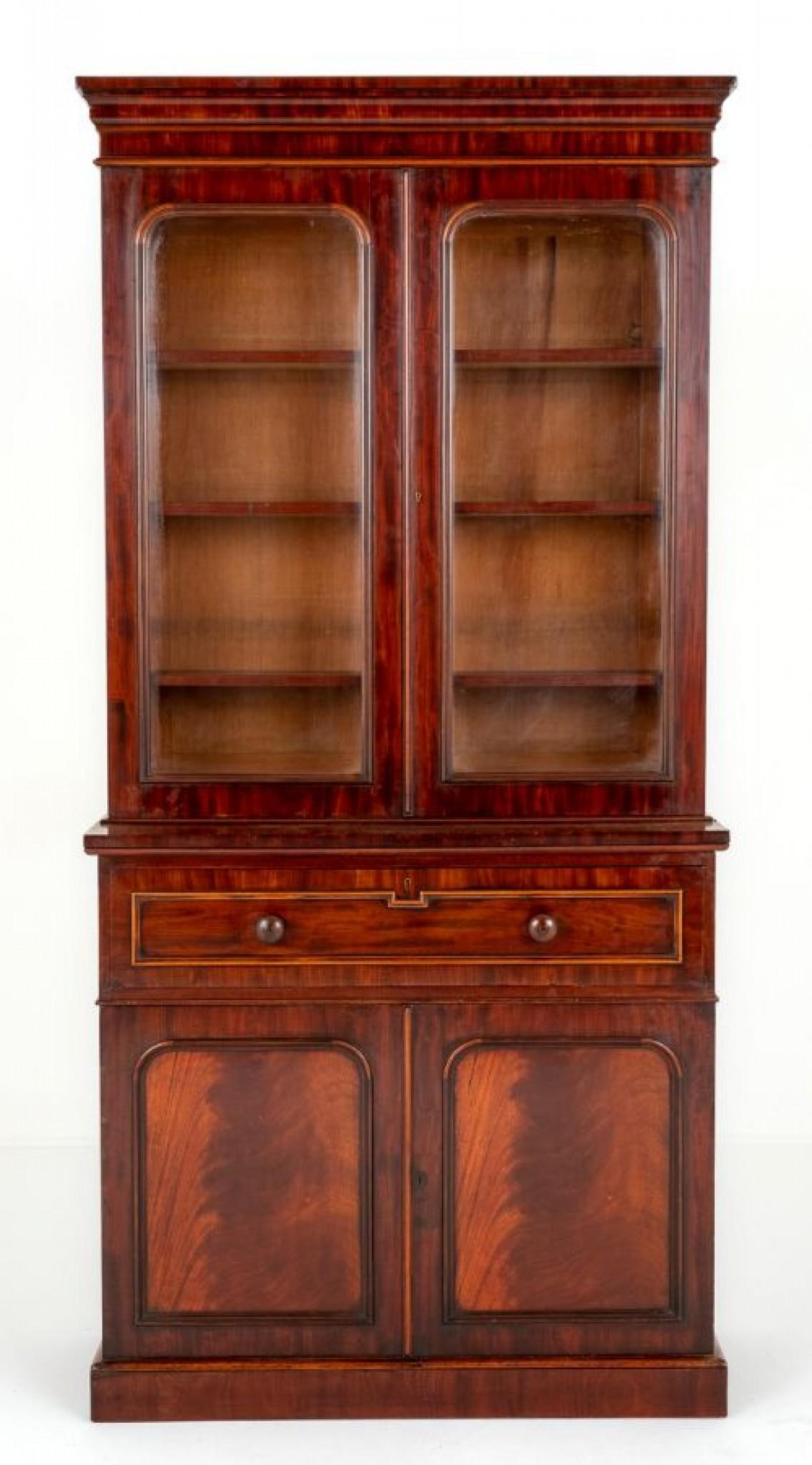 Victorian Mahogany Glazed Bookcase.
This Bookcase Stands upon a Plinth Base.
Circa 1860
The Lower Section Having 2 Paneled Doors, 1 Mahogany Lined Drawer with applied Moldings and Turned Knobs and Feature Decorative Flame Mahogany Veneers.
The Upper