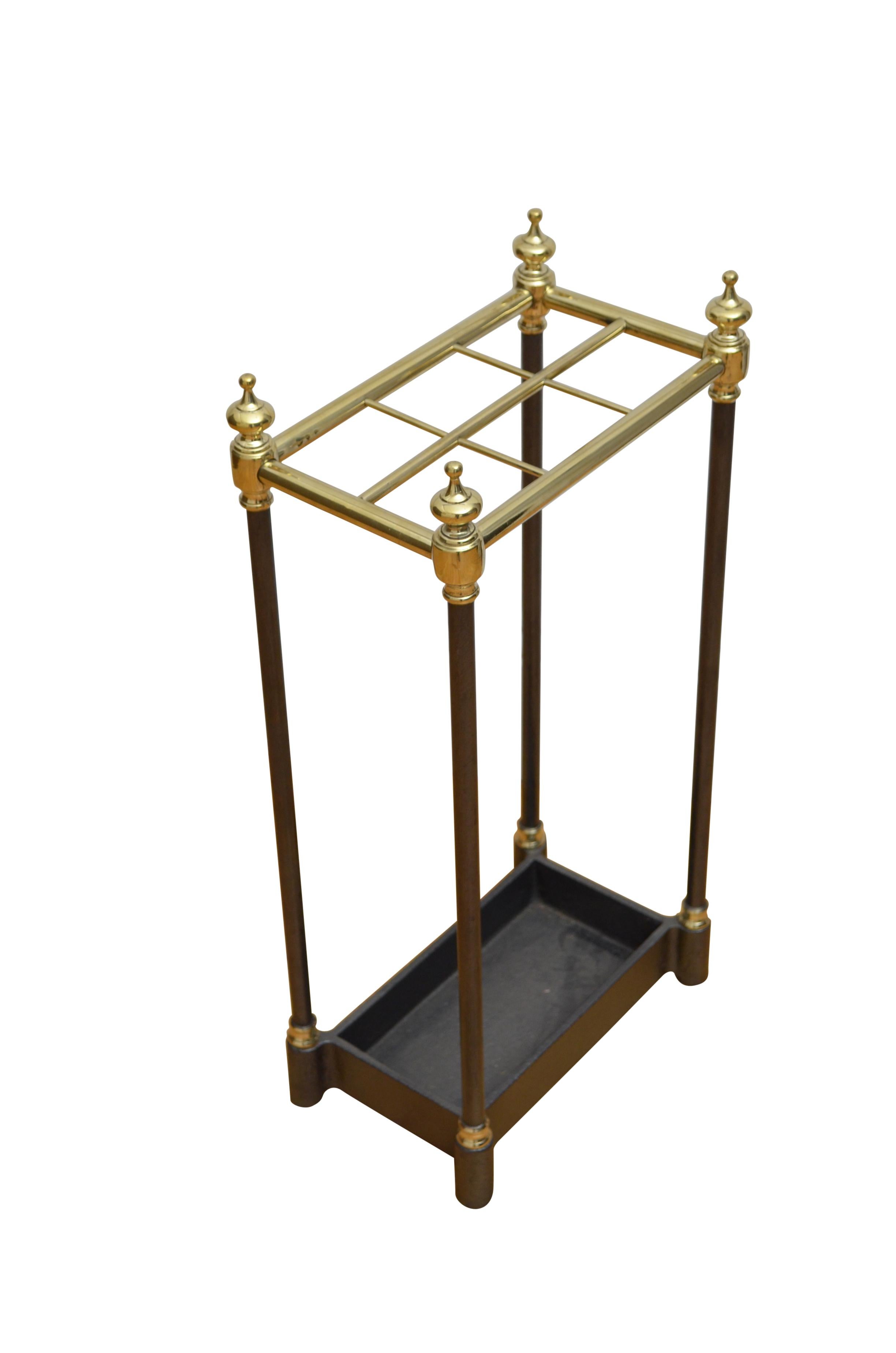 K0560 Victorian umbrella stand in brass with ebonised uprights having six umbrella or walking sticks divisions flanked by finials and cast iron drip tray. This antique umbrella stand has been cleaned and polished and is ready to place at home.