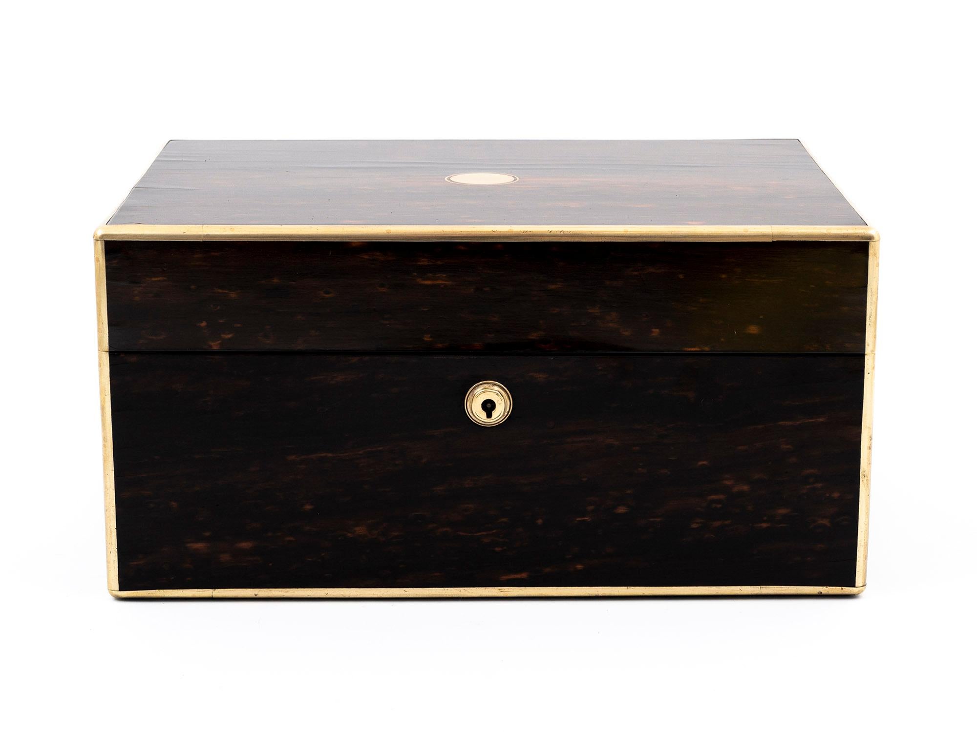 A secret jewellery drawer and love letter compartment is inside this beautiful antique coromandel jewellery box. This box has quadrant brass edging, sturdy flush-fitting carry handles, a vacant initial plate on the top, and an escutcheon on the