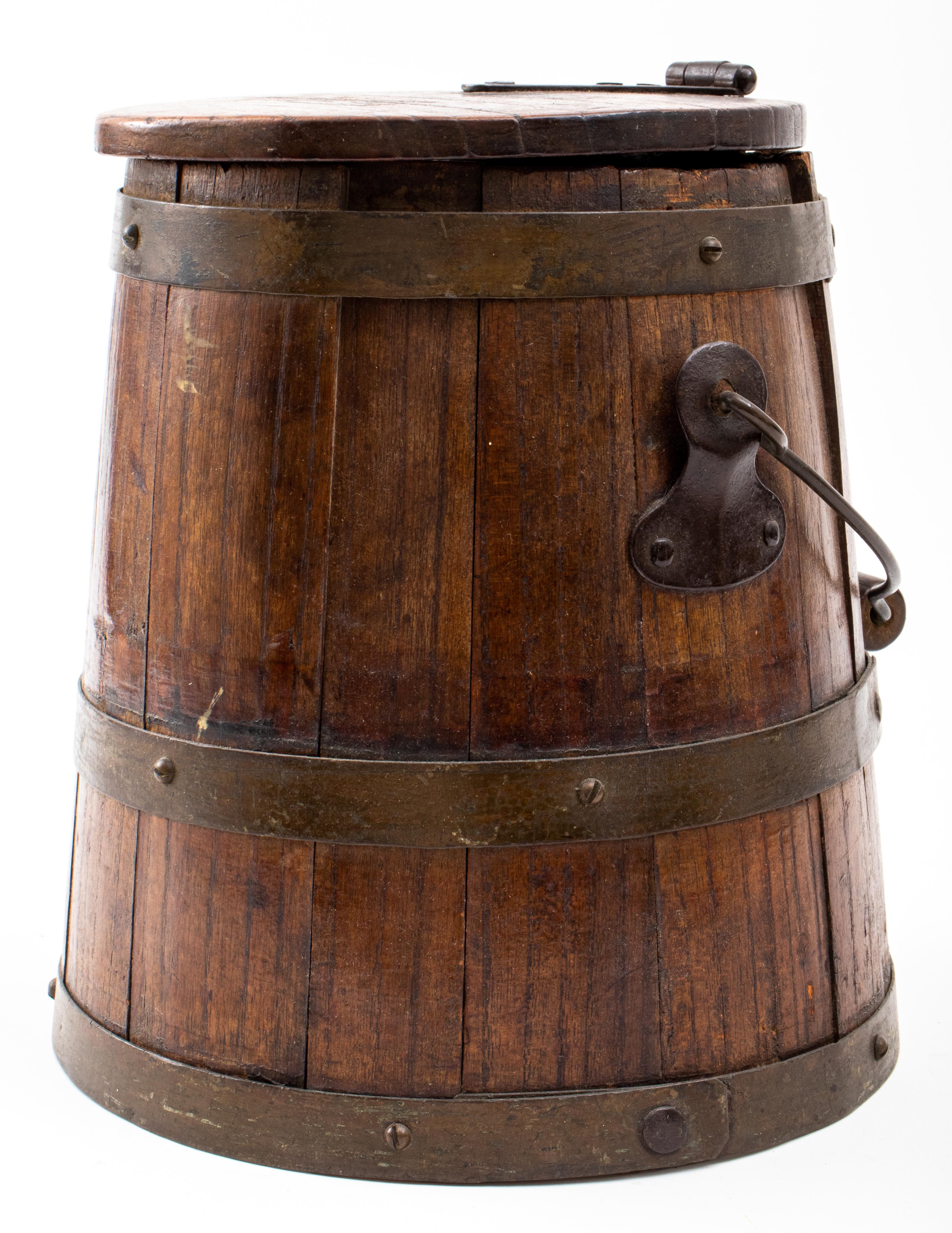 Victorian brass-bound oak milk pail of typical form with three brass straps, a shaped wire handle, and hinged lid. 
Measures: 10