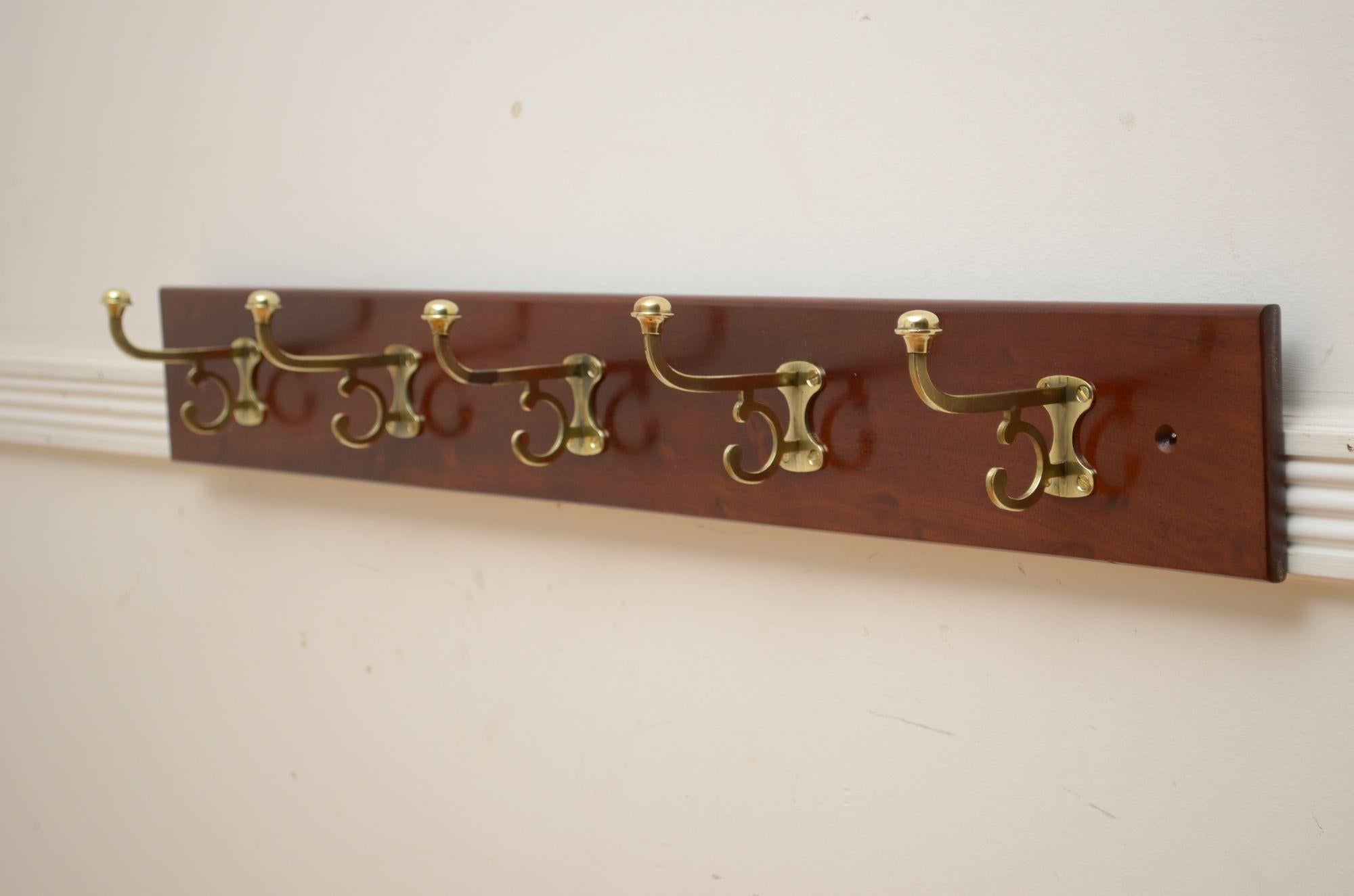 0287 Elegant Victorian coat rack with five brass double coat hooks and solid mahogany backing. Cleaned and polished, all in home ready condition .c1880
H4 3/4