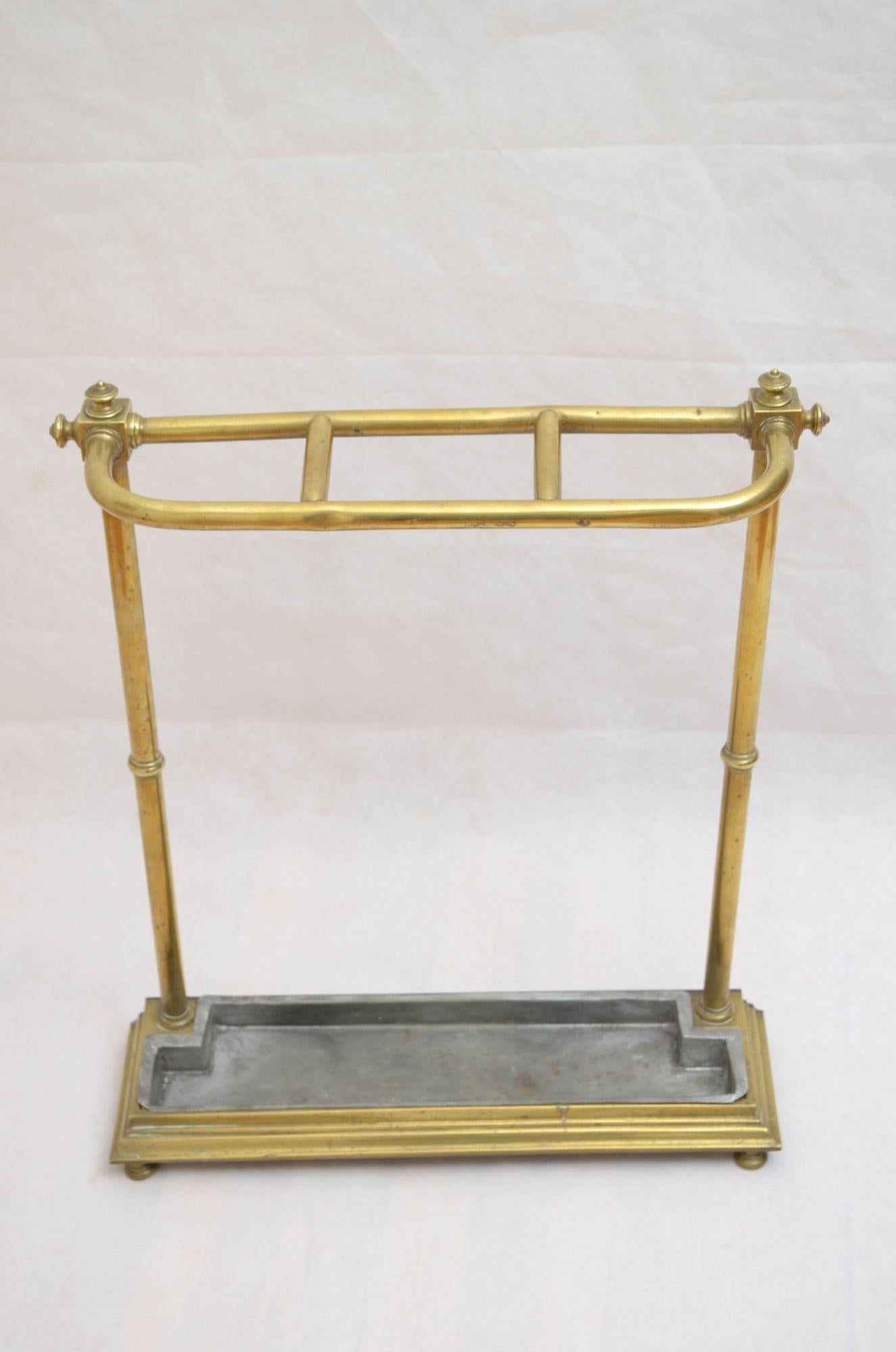 k0255A Insolito portaombrelli vittoriano in ottone, con tre divisioni e terminali molto decorativi a reticolo sulla parte superiore e sui lati, sollevato su montanti a reticolo che terminano in una base a gradini con vaschetta di raccolta