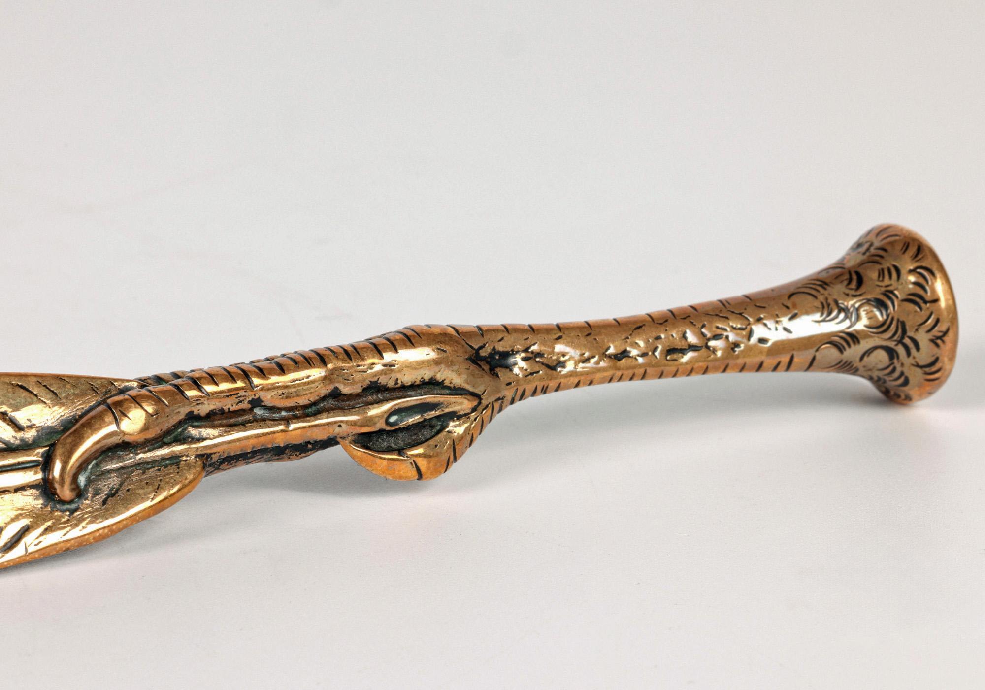 A superb quality brass bird claw and feather shaped letter opener and desk seal dating from the 19th century. This heavily and well-made desk accessory is modeled as a bird claw handle holding a letter opener formed as a feather. The detail is hand